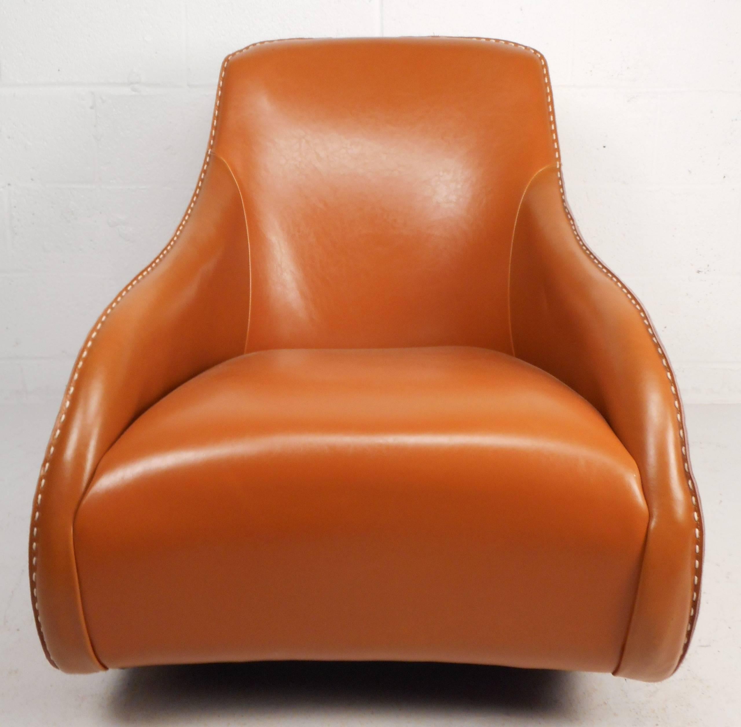 Beautiful contemporary modern rocking chair features a unique bucket seat design that's sure to provide comfort and style. Stunning piece is covered entirely in orange leather upholstery with stitched design running through each armrest and over the