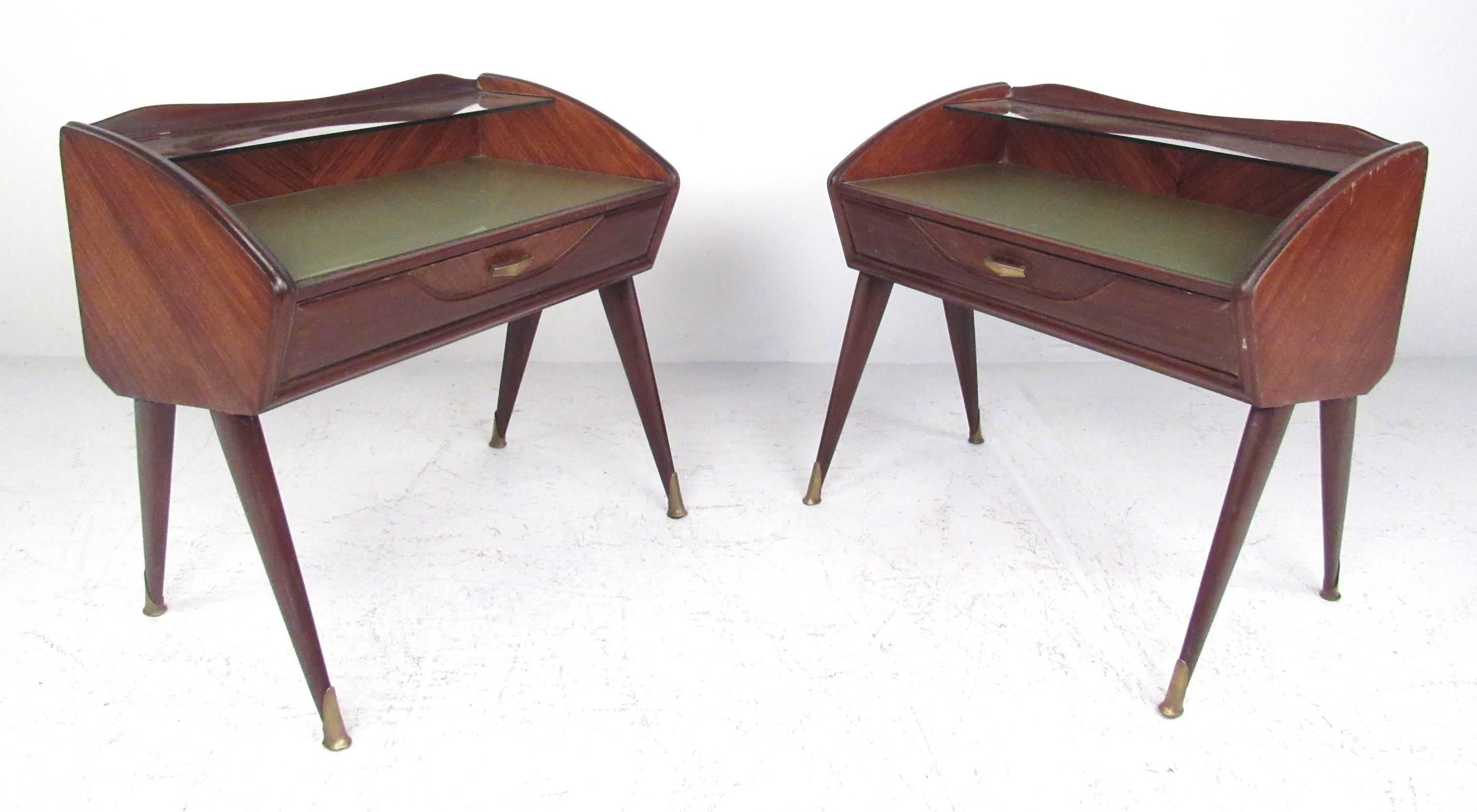 A pair of Italian Mid-Century nightstands in mahogany, with glass tops, a glass shelf and central drawer. Please confirm item location (NY or NJ) with dealer.