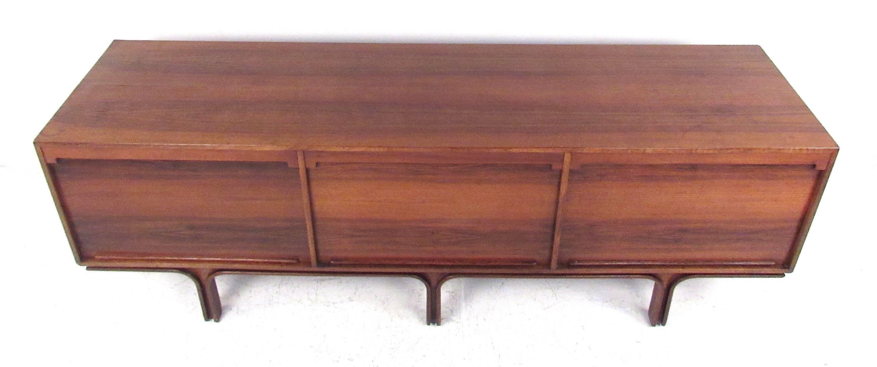 Rosewood sideboard with tambour doors designed by Gianfranco Frattini for Bernini. A well designed sideboard with three vertical tambour doors, a chest of drawers on one side and adjustable shelves in the other two. Please confirm item location (NY
