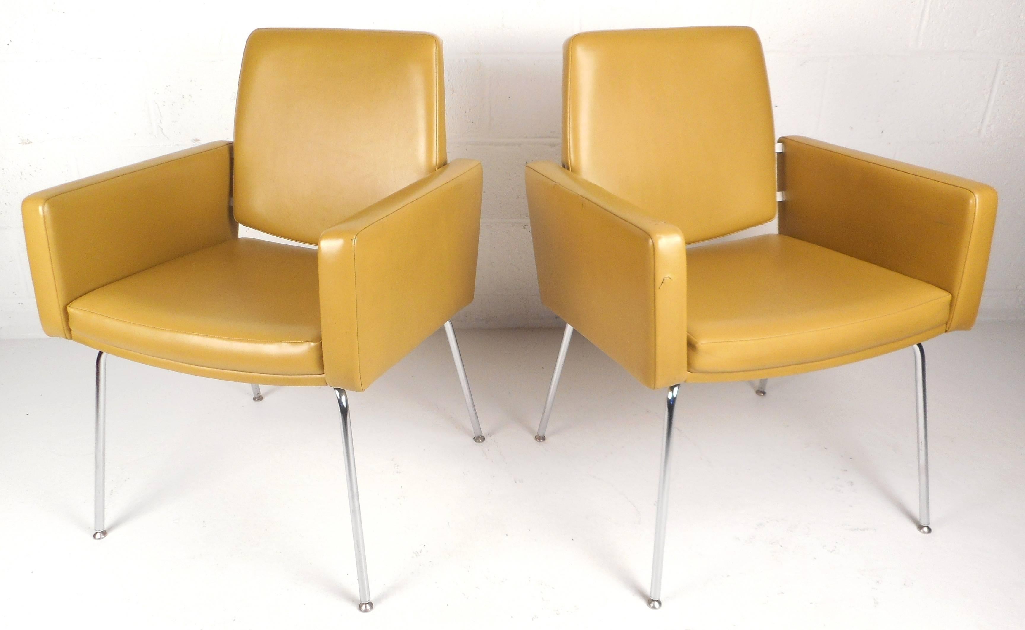 Stunning pair of vintage modern lounge chairs feature vinyl upholstery and unique bent rod chrome legs. The stylish floating backrest and thick padded seating offer comfort in any modern interior without sacrificing style. Please confirm item