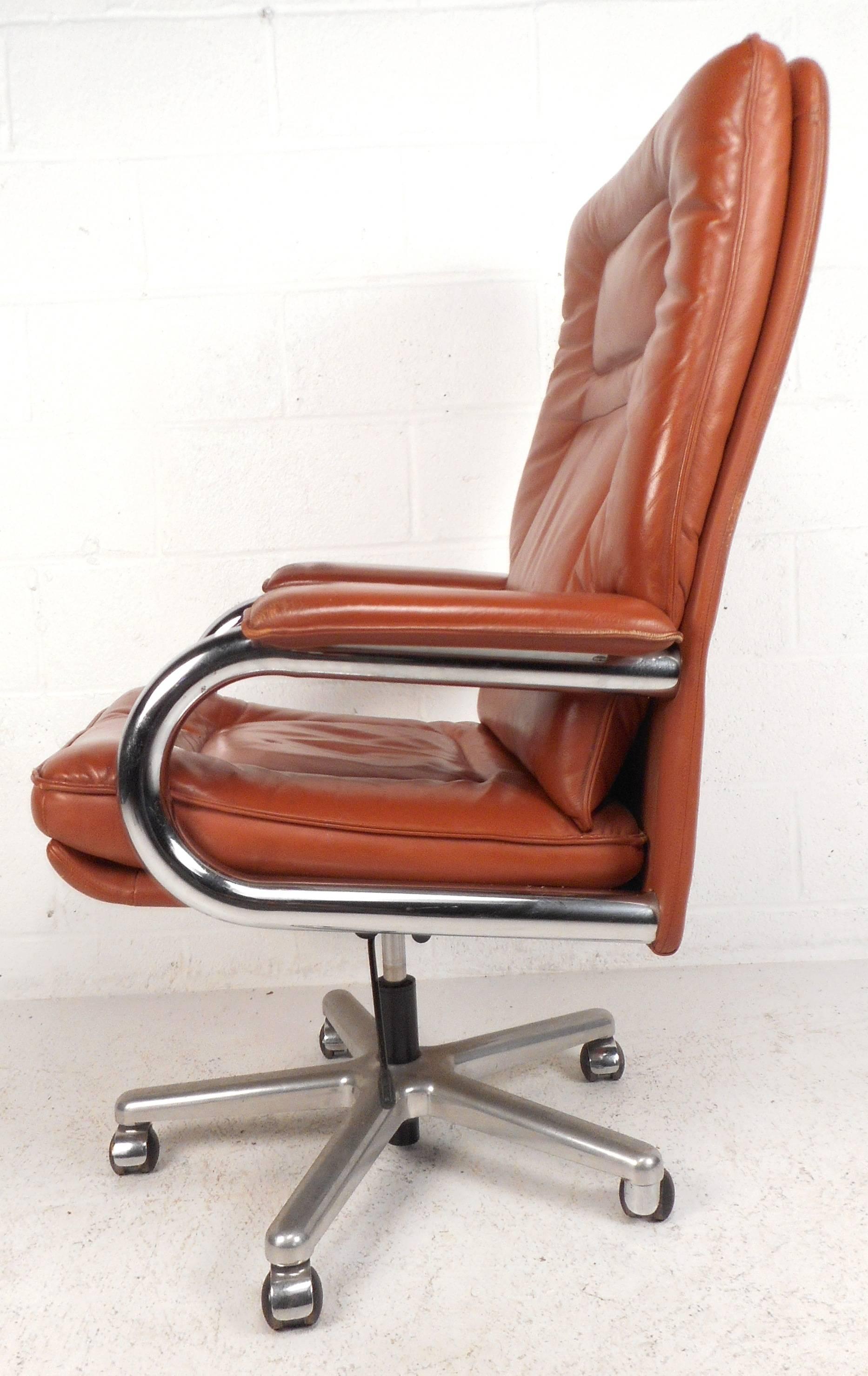 Impressive vintage modern Italian desk chair with tubular chrome sides and leather padded arm rests. Extremely wide and tall seating ensures comfort without sacrificing style. The sleek design offers the ability to swivel and is covered in beautiful