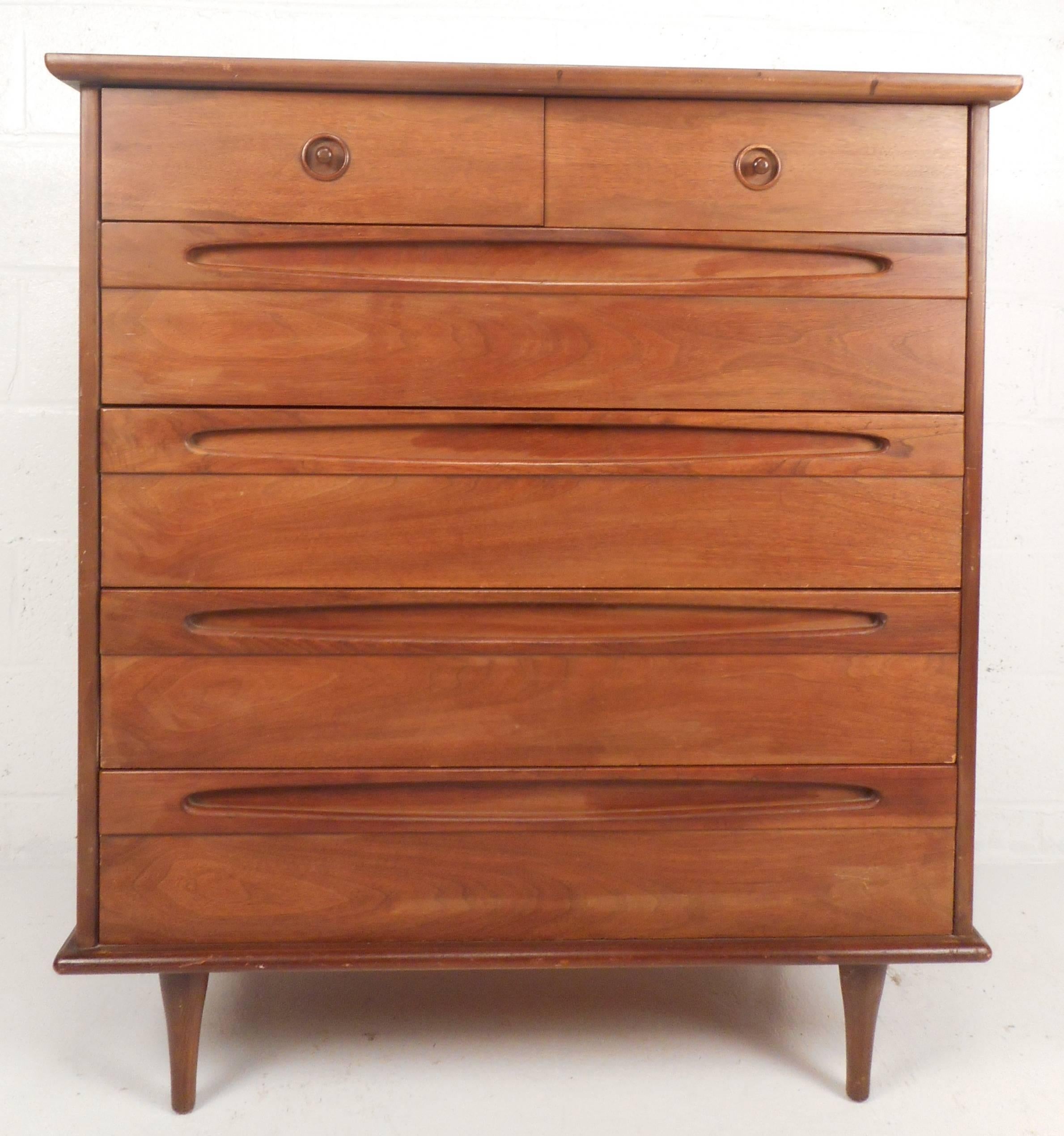 Stunning Mid-Century bedroom set includes a nine-drawer dresser and six-drawer highboy. Gorgeous walnut wood grain, tapered legs and dove tail joints add to the allure of this piece. These wonderful dressers feature oblong recessed pulls on both