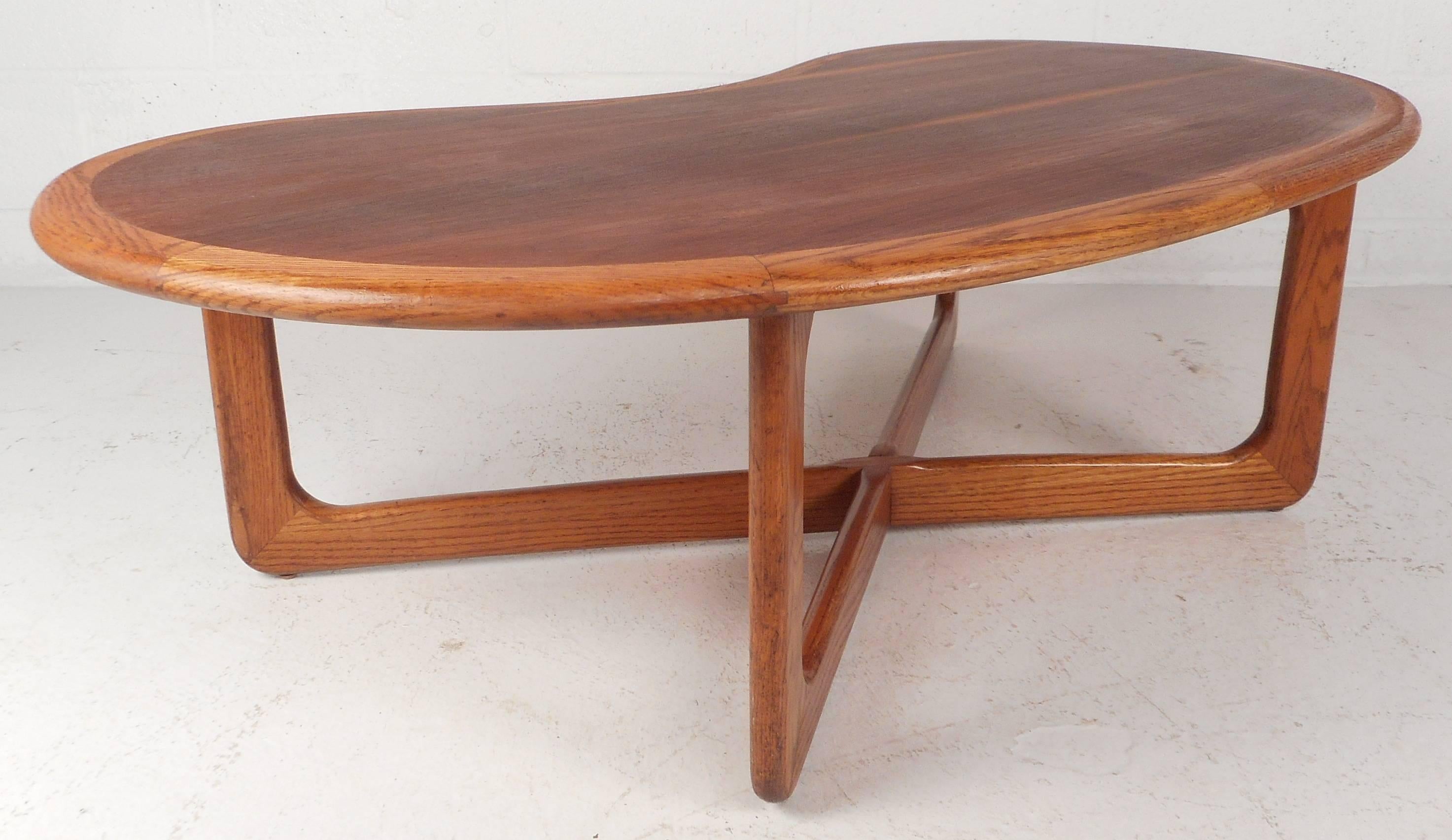 Elegant vintage modern coffee table features a unique kidney shape with a sturdy 