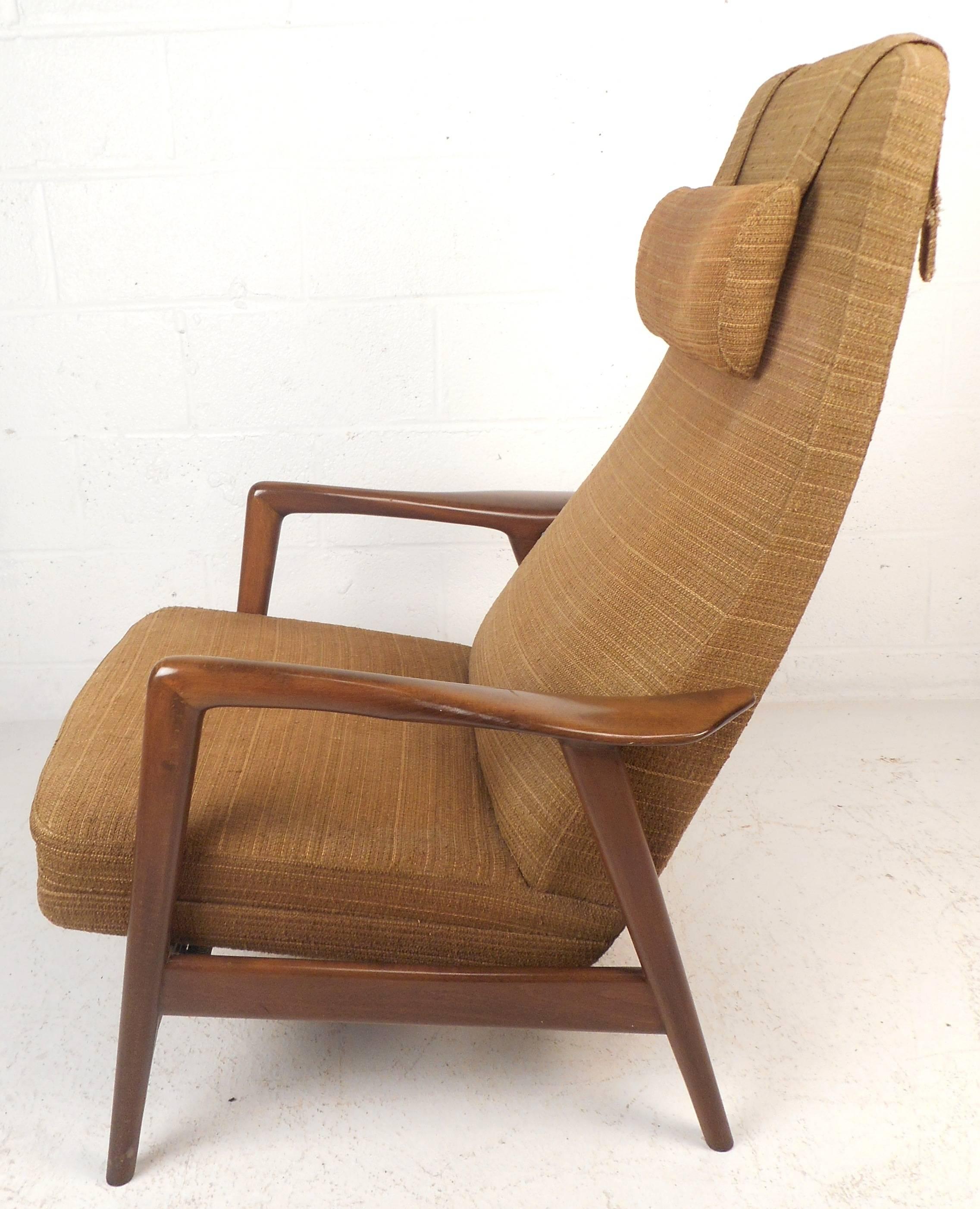 Impressive vintage modern lounge chair features a solid walnut frame, a high backrest, and thick padded cushions. Sleek design with sculpted arm rests and angled legs conveniently reclines ensuring optimal comfort in any setting. This Mid-Century