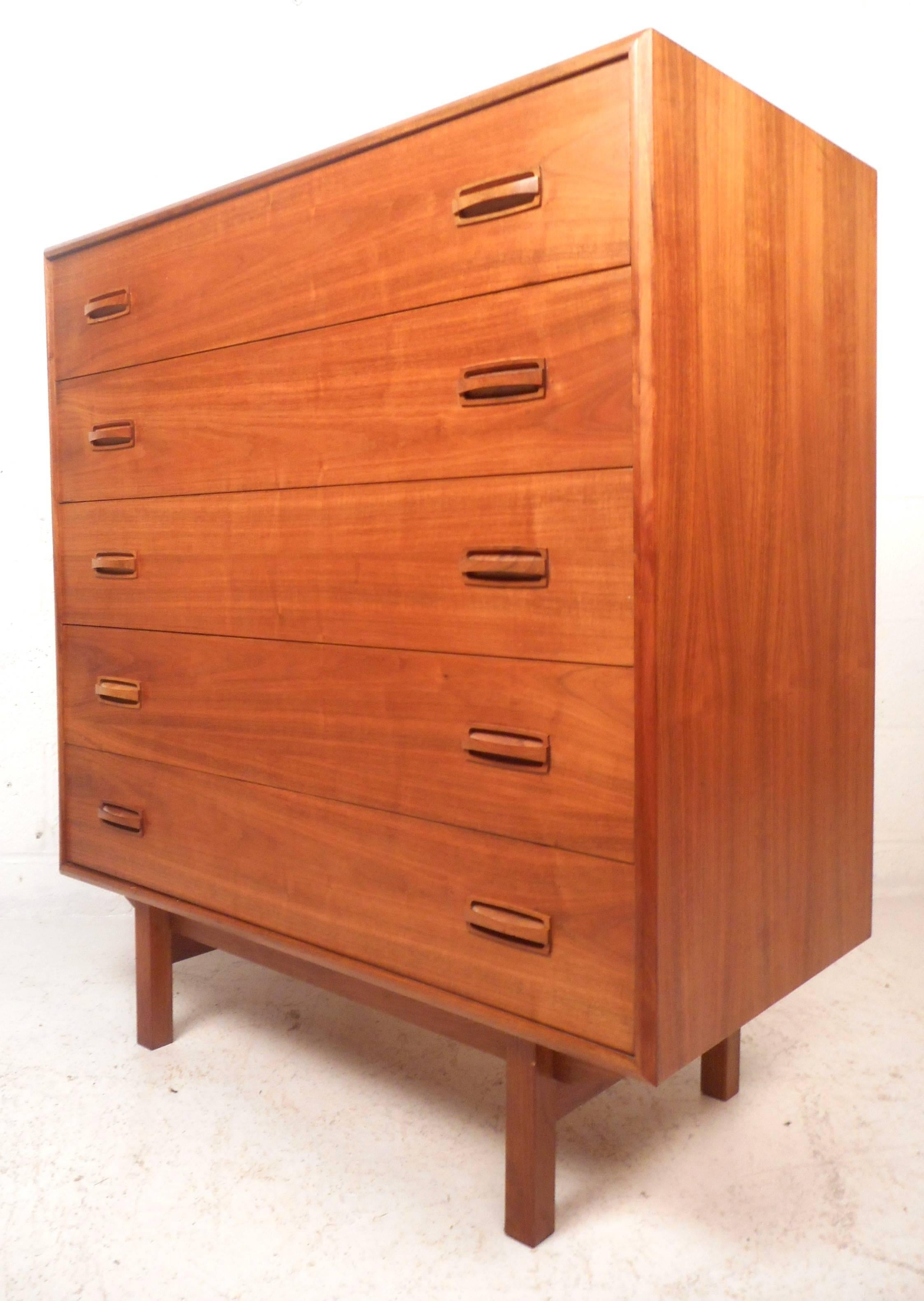 This impressive Mid-Century Modern bedroom set features a large dresser with nine hefty drawers and a highboy with five drawers. Rich vintage teak finish, wonderful sculpted drawer pulls, and clean lines showcase the quality of these elegant case