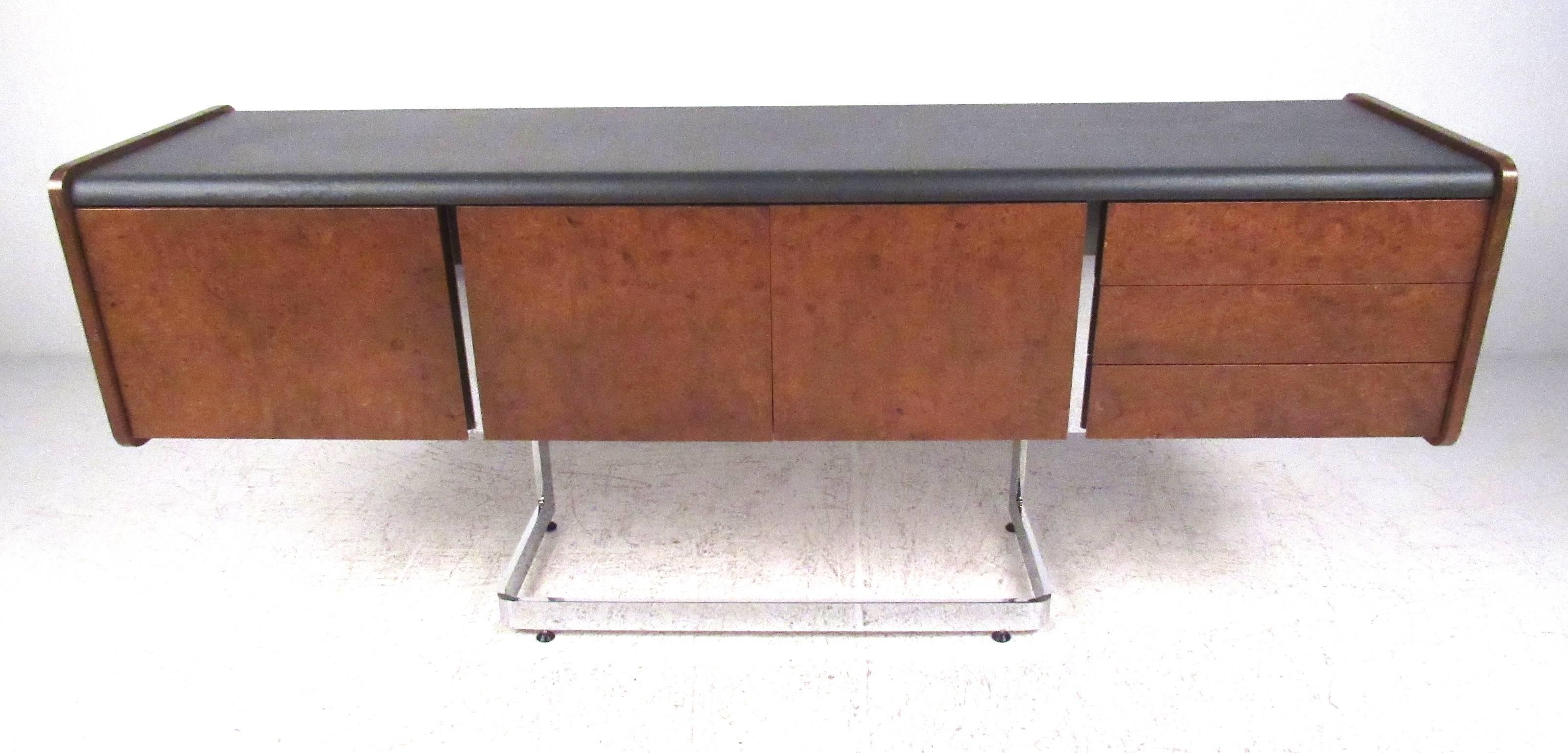 Ste. Marie & Laurent credenza with black leather top, deep file drawer, three pencil drawers and center storage cabinet, cantilevered onto a polished chrome base. Please confirm item location (NY or NJ) with dealer.