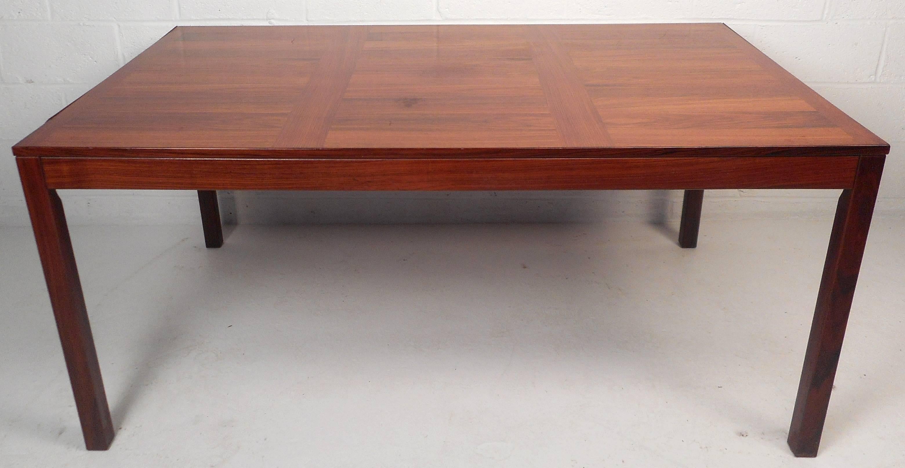 This impressive vintage modern dining table features stylish lined in lays on the top and an elegant rosewood finish. Sleek two-tone design and sturdy construction add to the allure. Beautiful Mid-Century piece makes the perfect addition to any