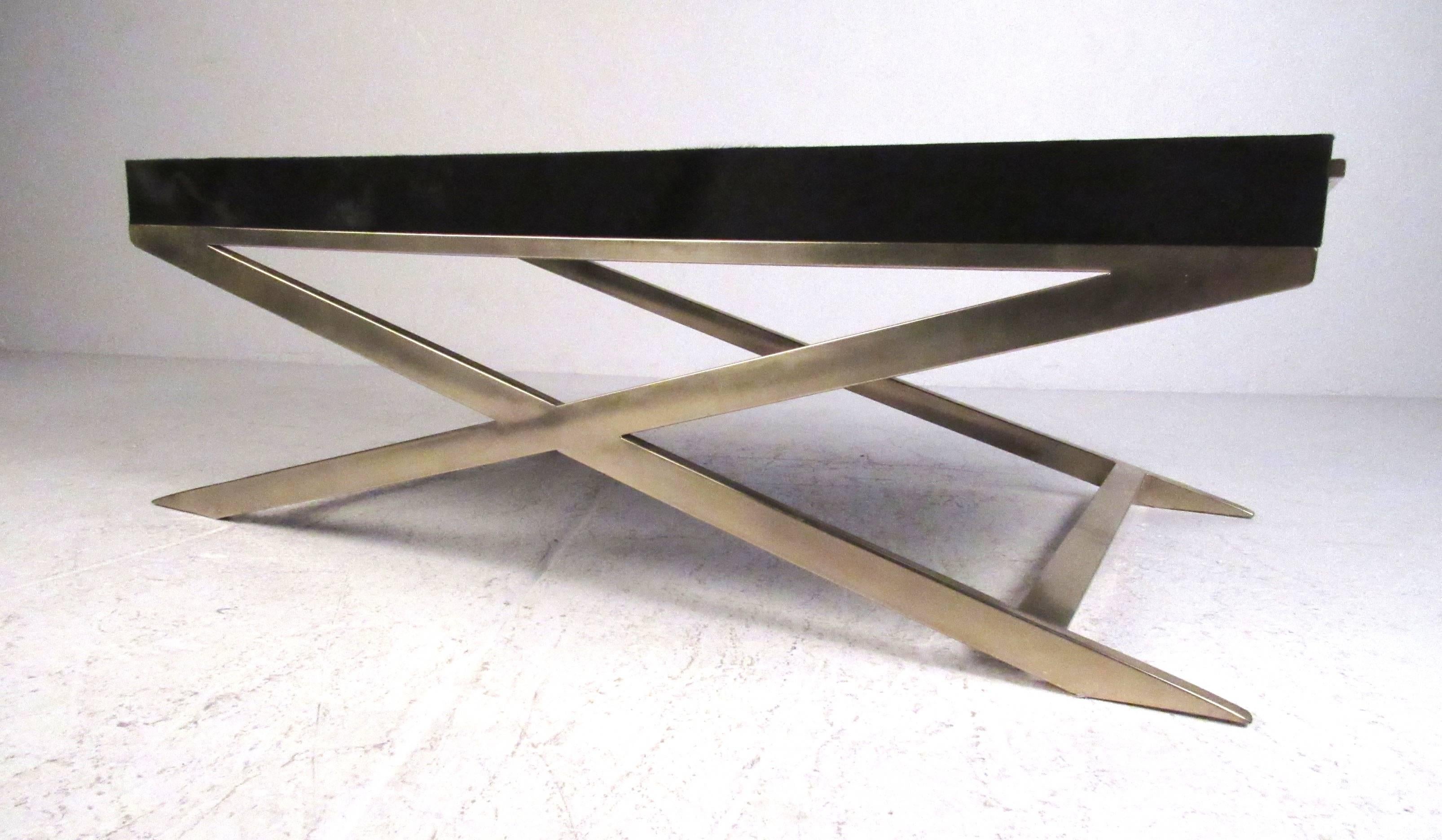 Elegant brushed brass X-base shadow box style coffee table. Top is covered in a rich black faux fur hyde with a beveled glass top insert. Please confirm item location (NY or NJ) with dealer.