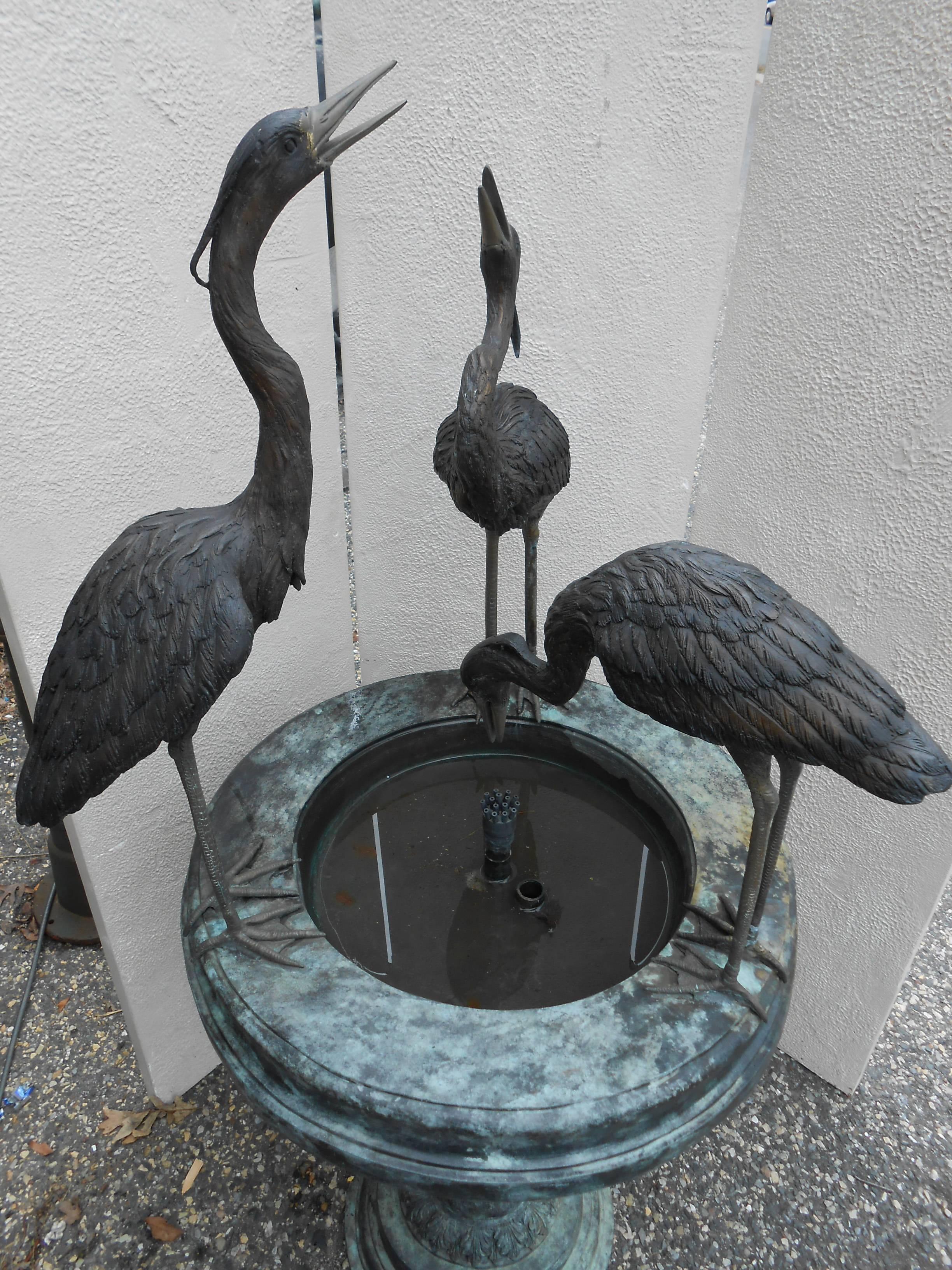 This stunning bronze fountain features three egrets or herons on the edges of a round reservoir with a multiple hole spout in the center. The sculpted pedestal base and gorgeous patinated finish add to the allure. Exquisite detail from the base all