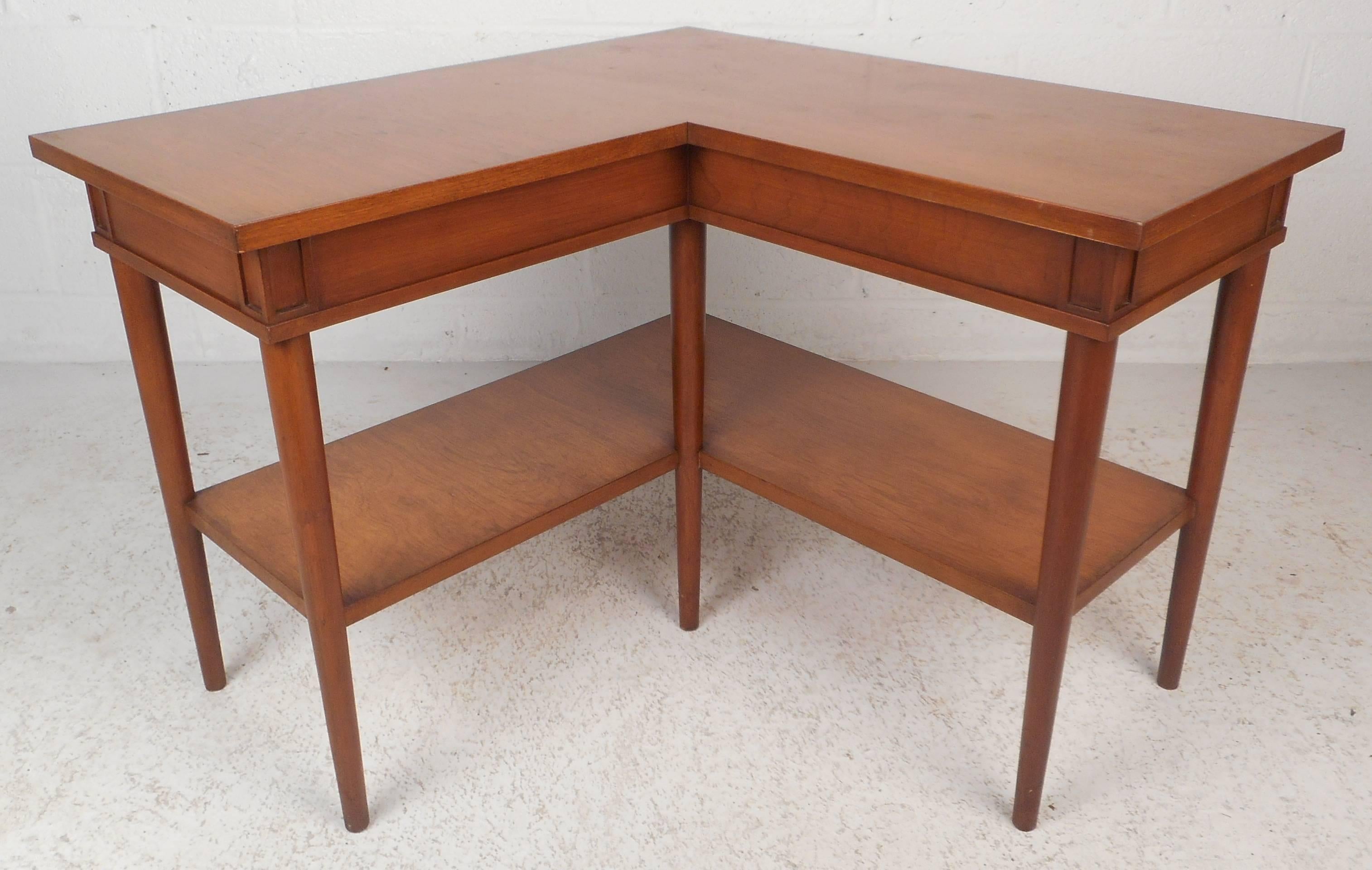 This versatile vintage modern piece can be used as a shelf, coffee table, or corner table. Sleek design with tapered legs and two tiers for added convenience. Beautiful walnut wood grain and clean lines add to the Mid-Century appeal. This unique