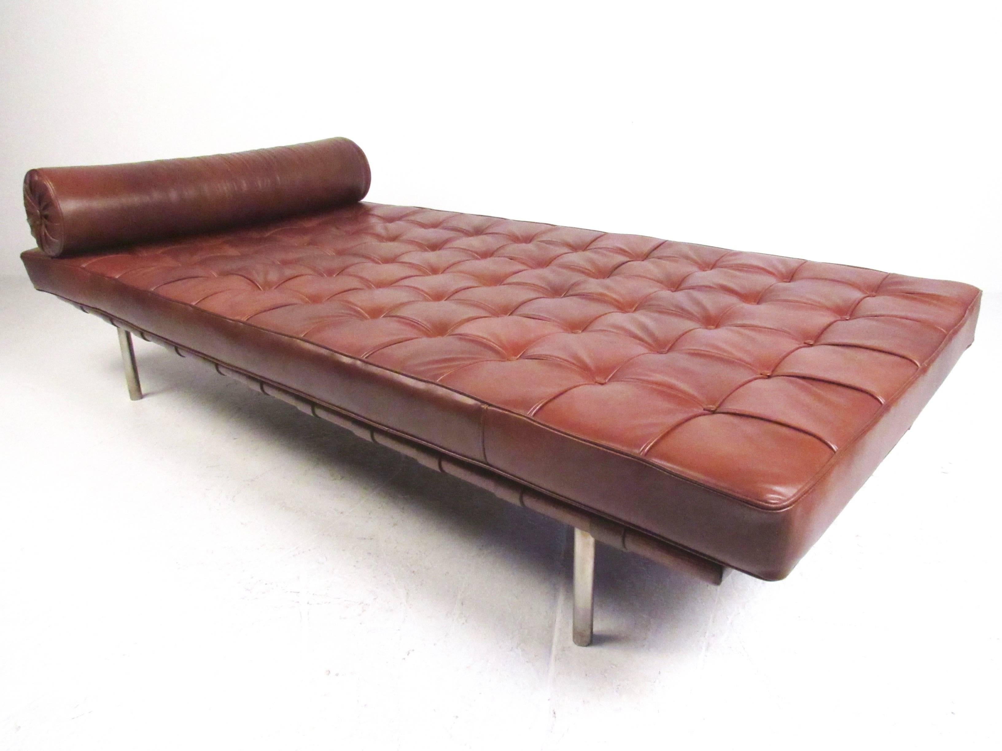 This stylish Mid-Century Modern daybed by Ludwig Mies van der Rohe was designed for Knoll Associates and features a hardwood frame with leather straps, topped with a plush tufted leather cushion. Matching cylindrical pillow adds style and comfort to