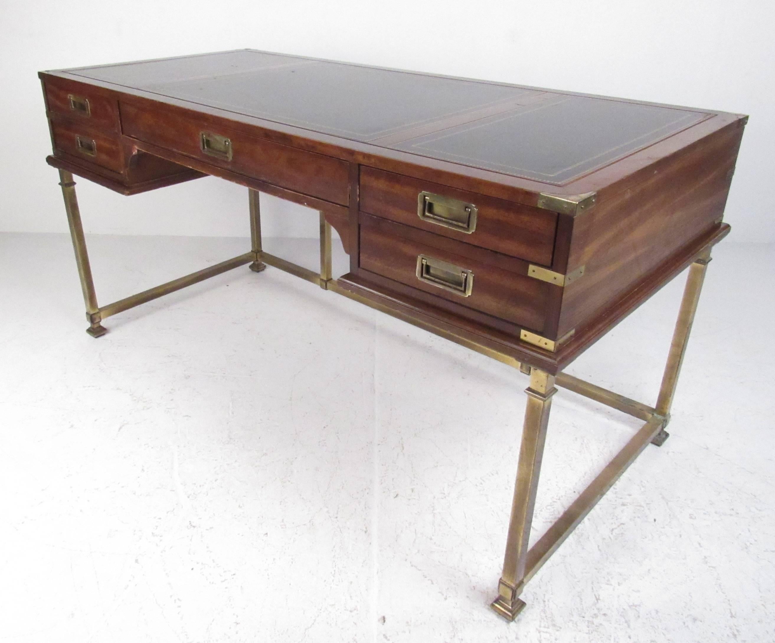 Mid-Century Modern campaign desk by Sligh Furniture company of Holland, Mich. Made of mahogany with leather top and brass base, it has five drawers and is finished on all sides. Please confirm item location (NY or NJ) with dealer.
