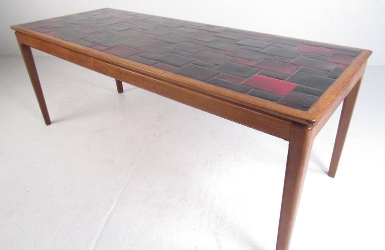 Vintage colorful ceramic tile table, circa 1970s. A sturdy walnut frame with slender legs makes this table the perfect addition to any home, business, or office. Please confirm the item location (NY or NJ) with dealer.
  