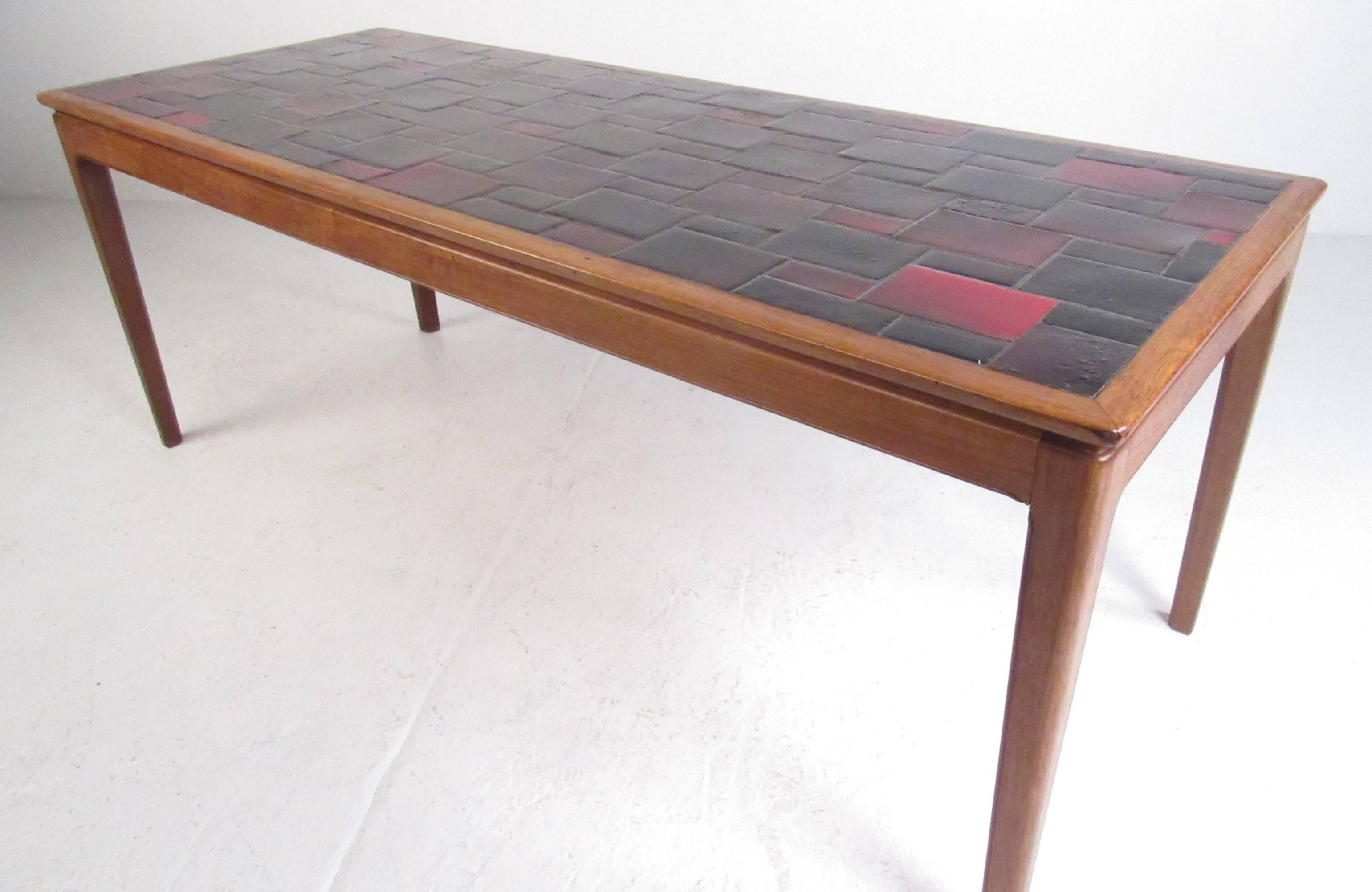Tavolo in ceramica colorata vintage, anni '70 circa. Una robusta struttura in noce con gambe sottili rende questo tavolo l'aggiunta perfetta a qualsiasi casa, azienda o ufficio. Si prega di confermare la posizione dell'articolo (NY o NJ) con il