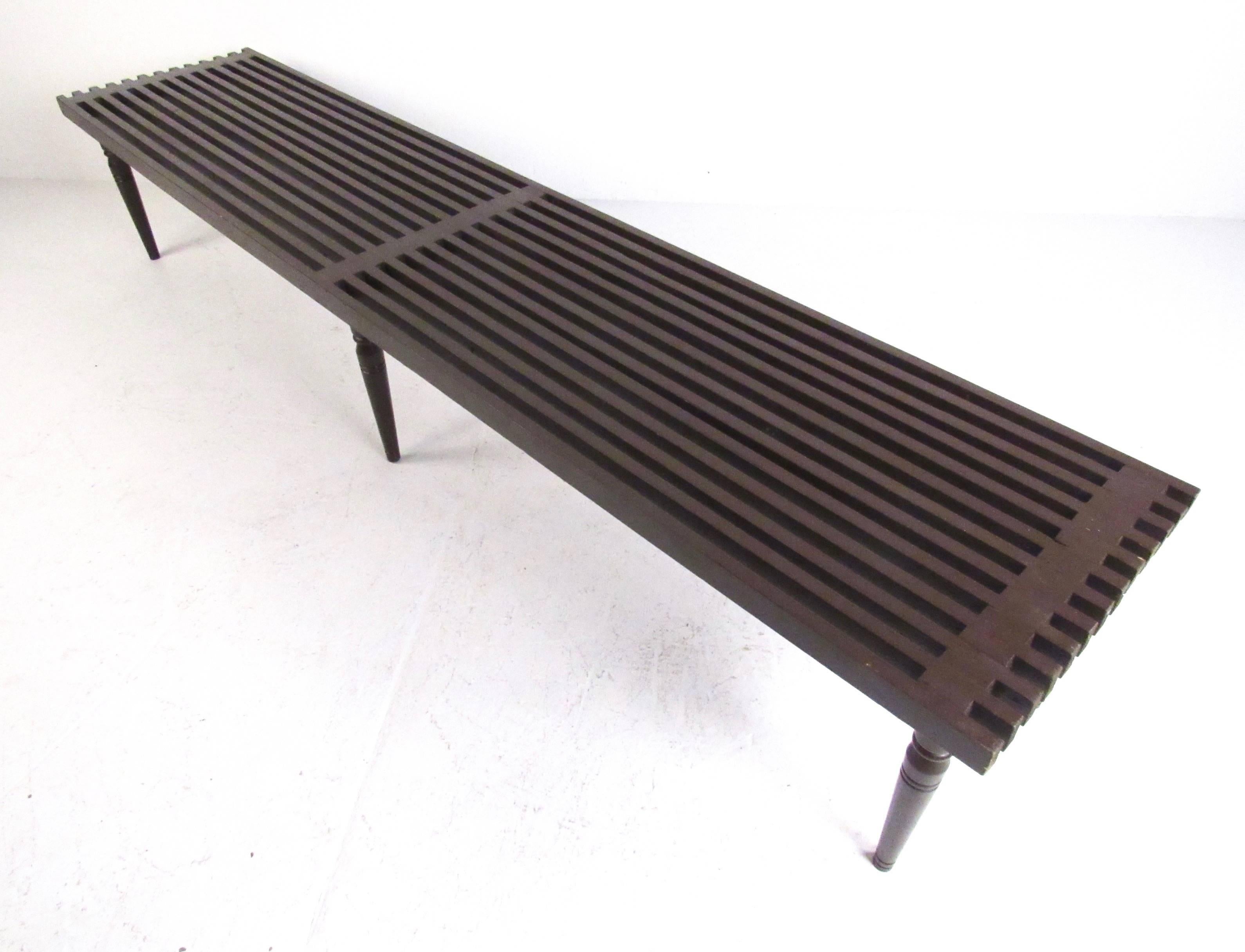 This vintage handmade wood slat bench features six tapered legs and measures over seven feet long. Mid-Century table makes a stylish addition to any interior as an occasional bench or slat coffee table. Please confirm item location (NY or NJ).