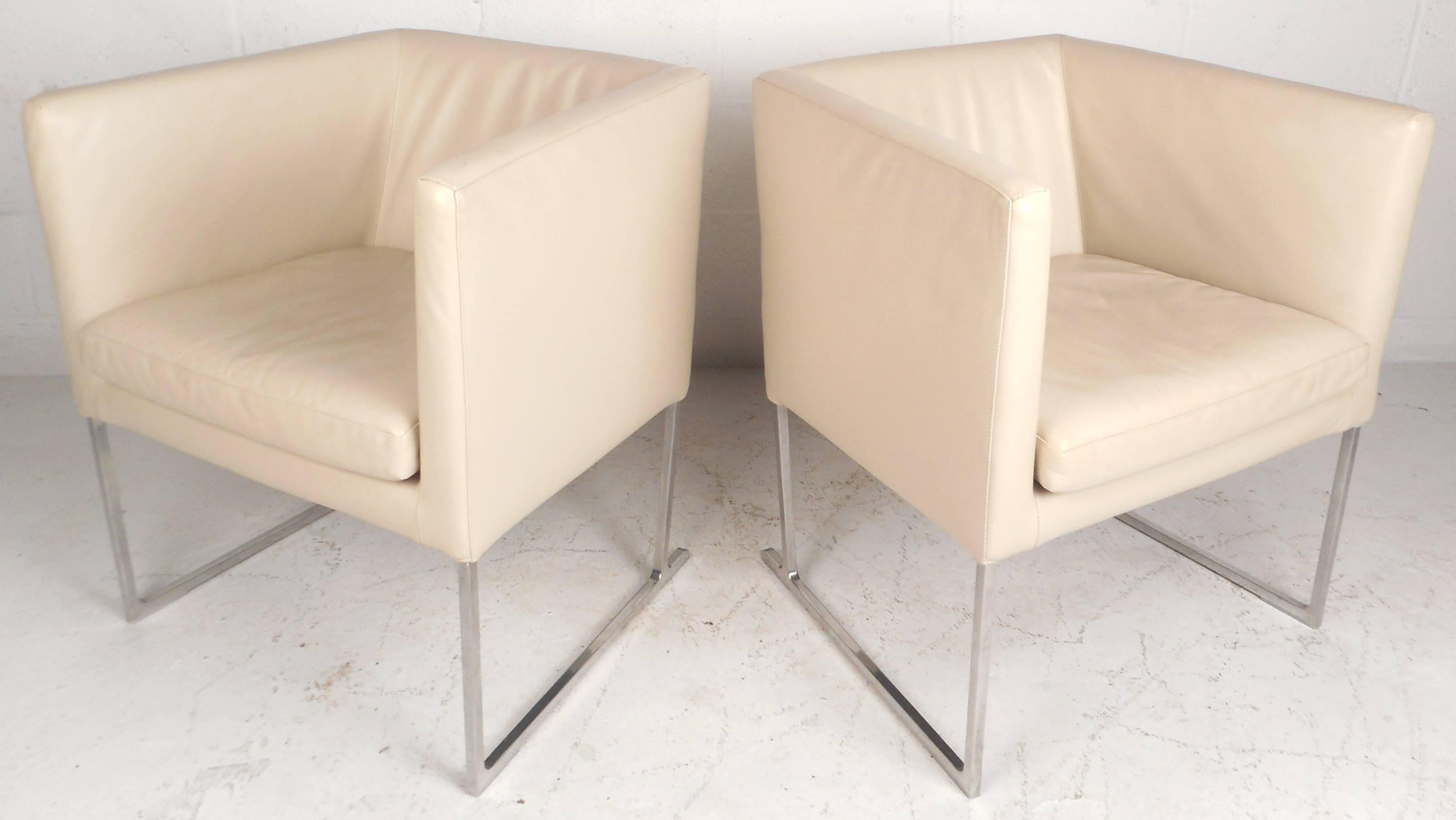 This beautiful pair of Contemporary modern Italian lounge chairs feature a unique cube shape with heavy chrome sled legs. This unusual pair is covered in white vinyl with a thick cushion and high arm rests. Quality design with straight lines ensures