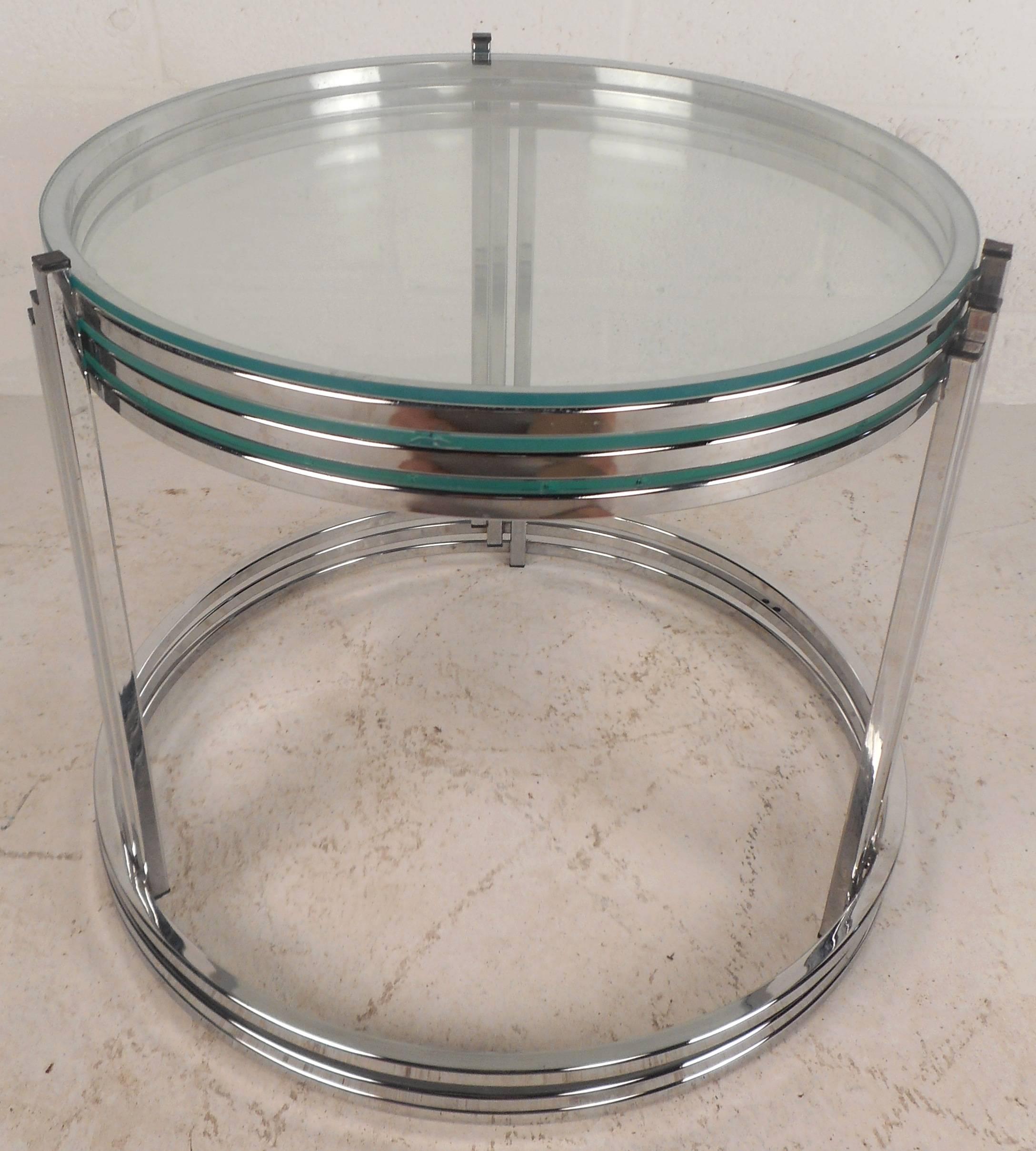 Elegant set of three vintage modern stacking tables feature a sleek circular chrome frame with vertical supports. Stylish design allows each table to sit comfortably on top of each other for convenient storage. The thick glass has a slight tint of