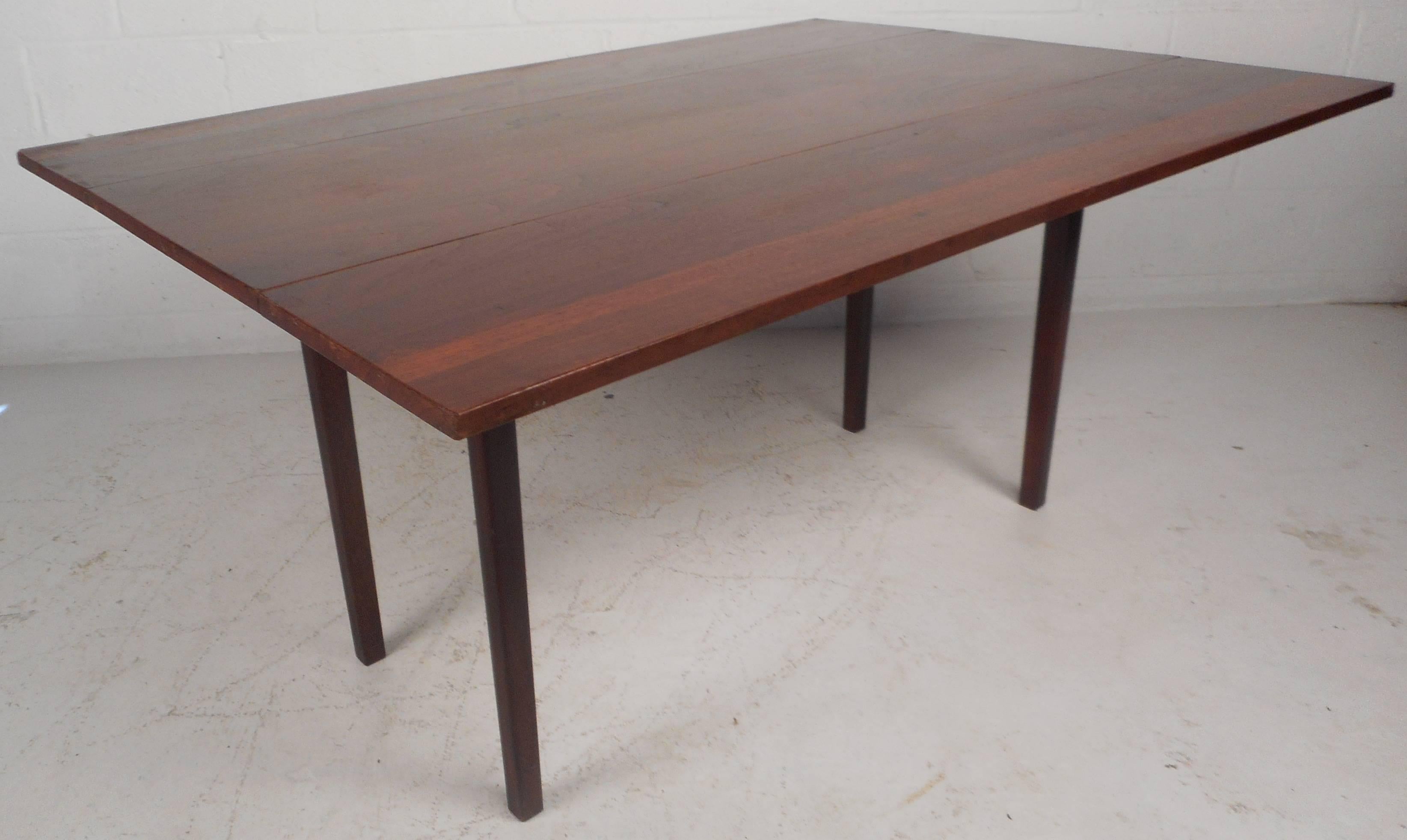 This elegant vintage modern dining table conveniently goes from 18.25