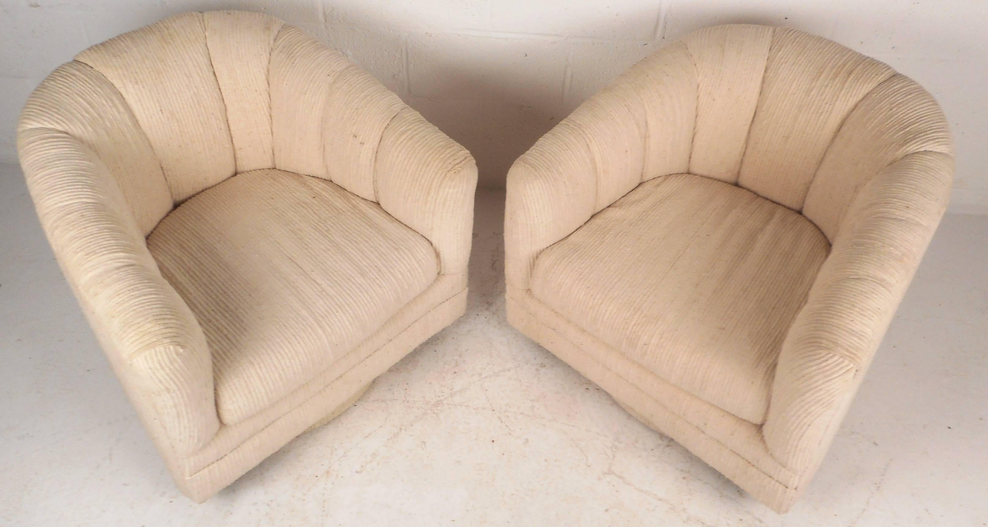 Beautiful pair of vintage modern lounge chairs with original plush cream colored upholstery. Unique design offers comfort and convenience in one stylish lounge chair with the ability to swivel. Thick padded cushions and barrel back rests make this