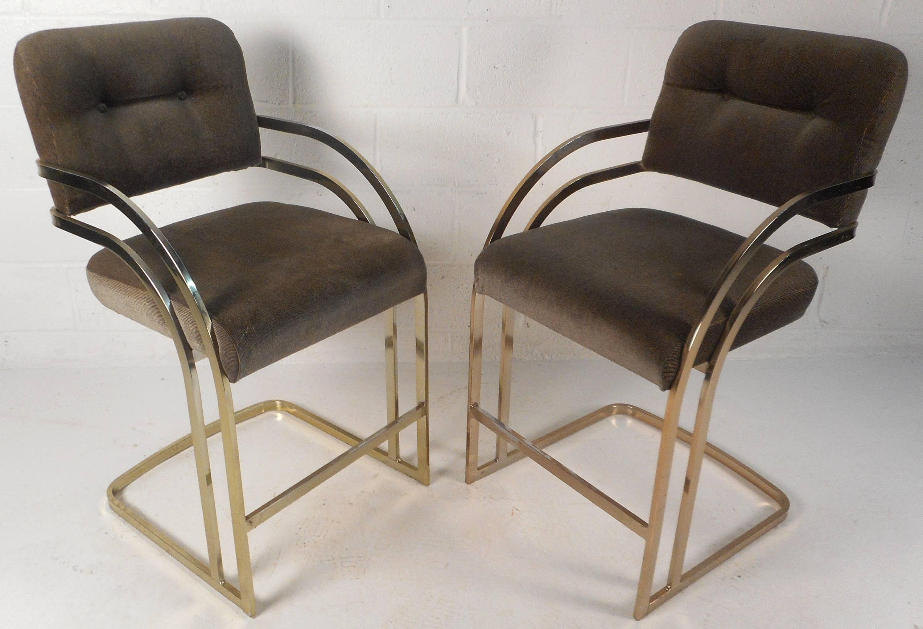 Stunning pair of vintage modern chairs feature a stylish cantilever brass plated frame with plush tufted upholstery. Unique ellipse shaped arm rests ensure optimal comfort. Double bar design provides sleek and sturdy seating that compliments any