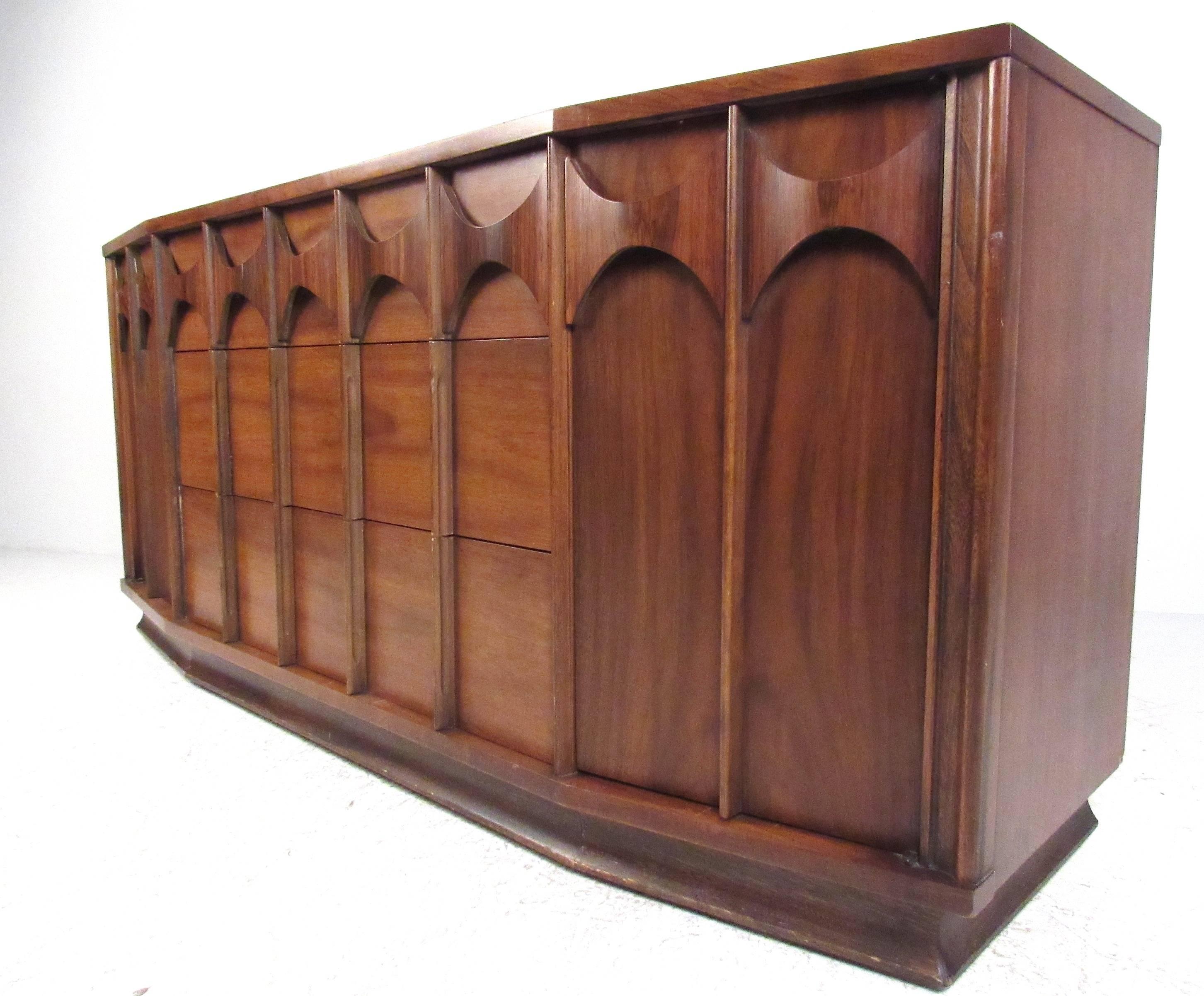 Brasilia style dresser by Kent Coffey for his Perspecta collection. Sculptural front walnut dresser consisting of three deep center drawers flanked by two doors with six additional drawers providing ample storage. Matching tall dresser and