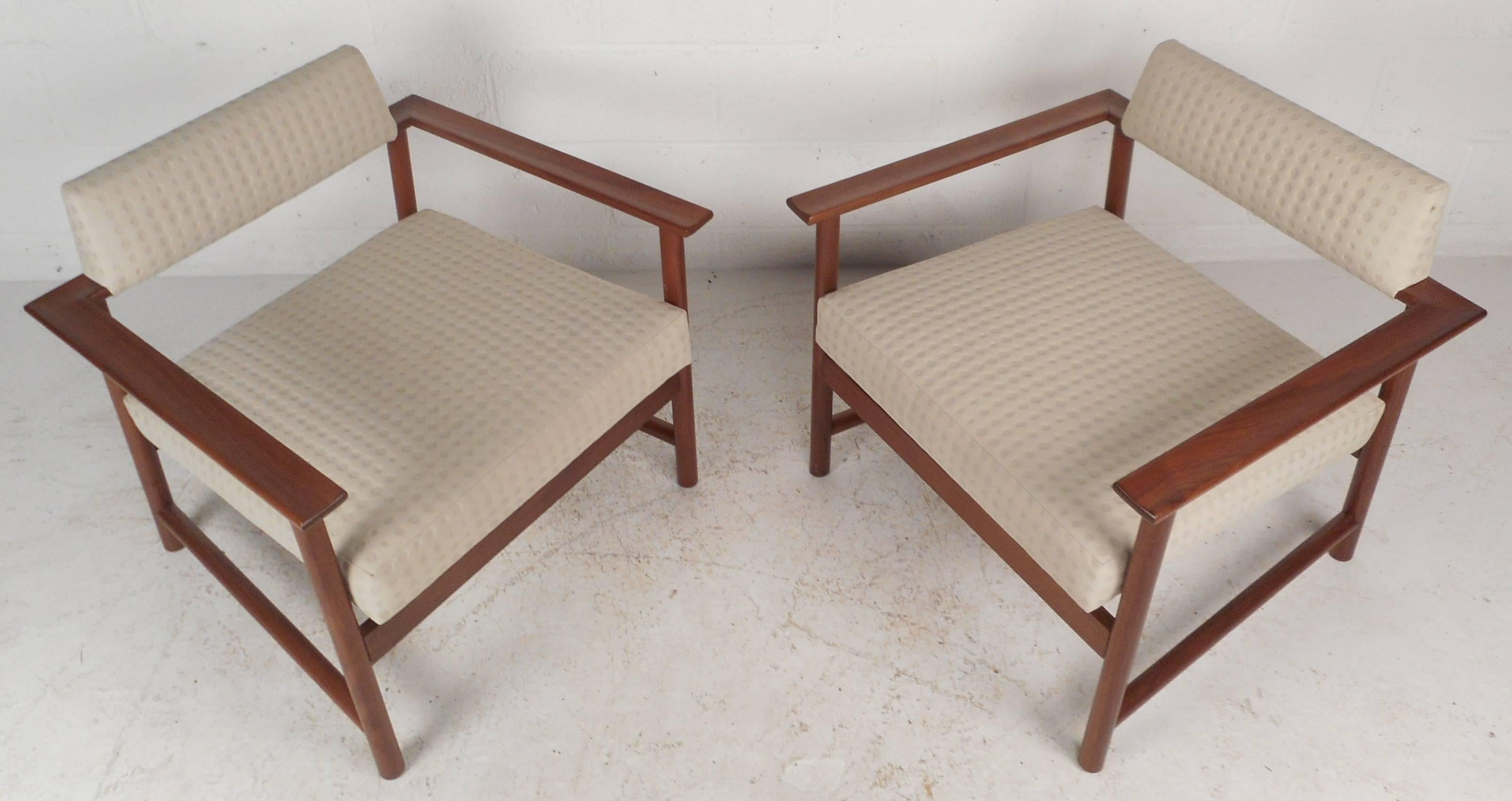 This beautiful pair of vintage modern lounge chairs feature an open frame design with a unique floating backrest. The solid walnut frame displays gorgeous wood grain and provides maximum sturdiness. Extremely comfortable pair with plush white