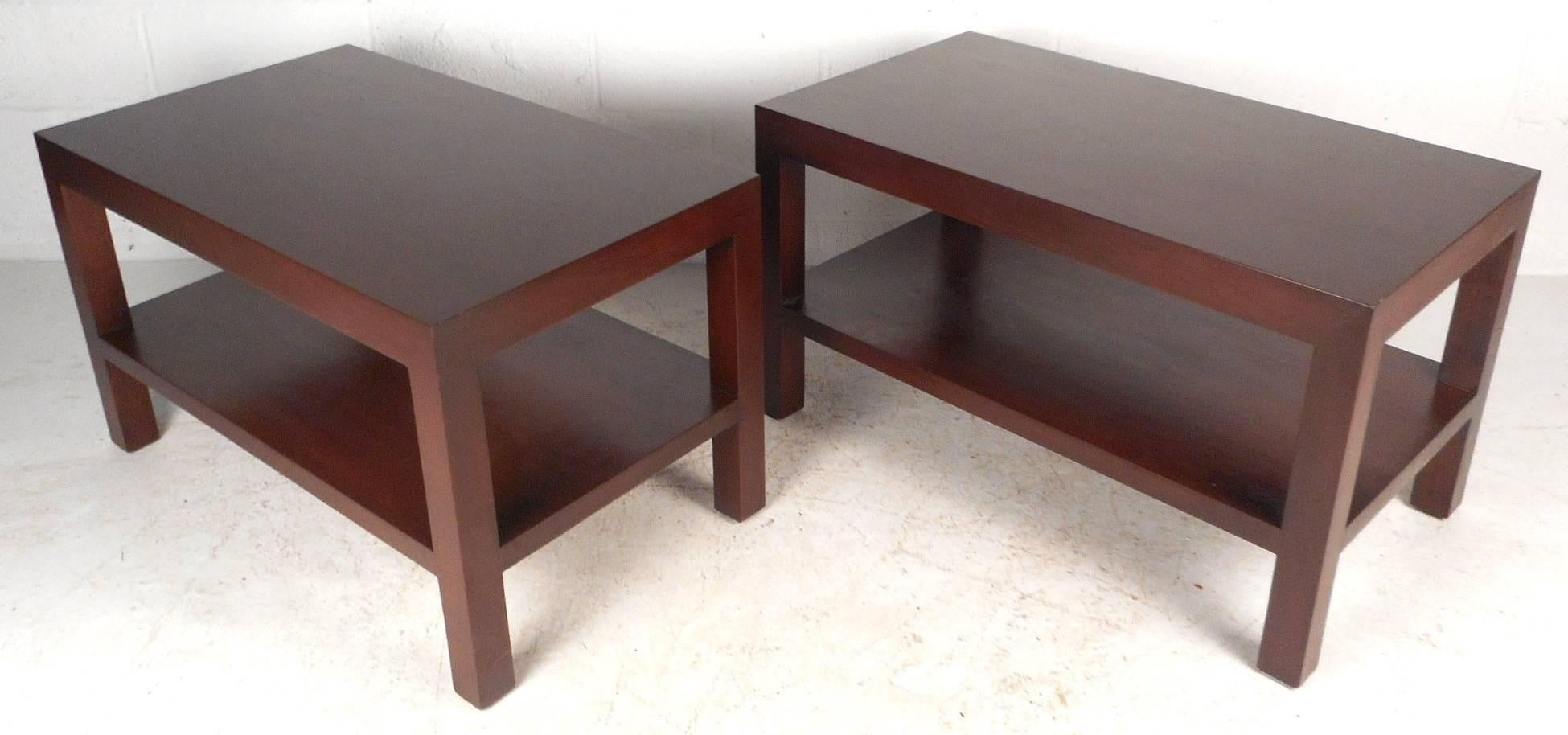 Beautiful pair of vintage modern side tables feature a straight line two tier design. The rectangular shape and solid dark walnut wood add to the mid-century appeal. This unique pair make the perfect addition to any home, business, or office