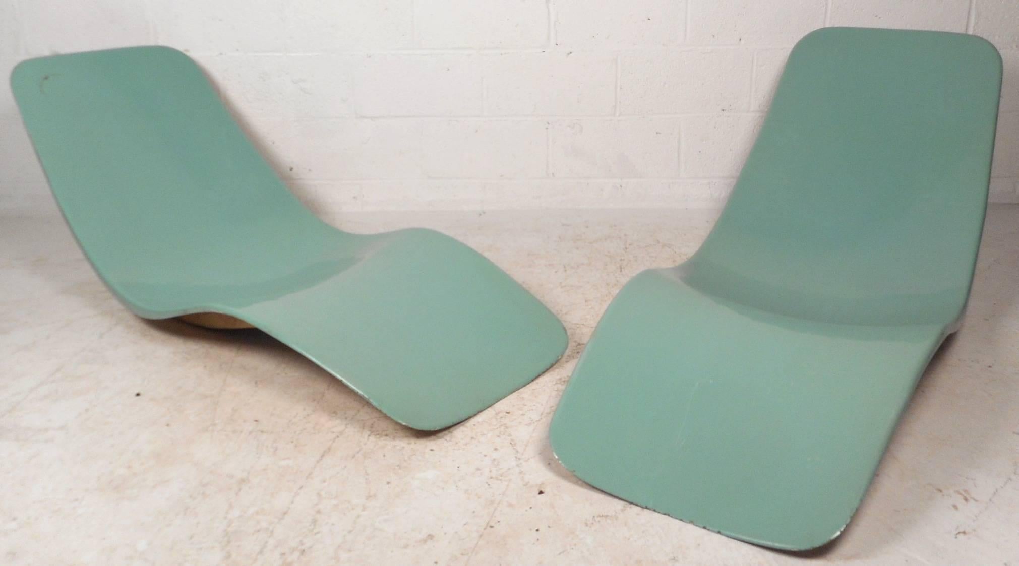 Amazing pair of vintage modern chaise lounges feature an elegant teal color and are made of fiberglass. Unique design has a sculpted frame to ensure maximum comfort. Smooth exterior with the perfect shape to contour to the body. Sleek outdoor pieces