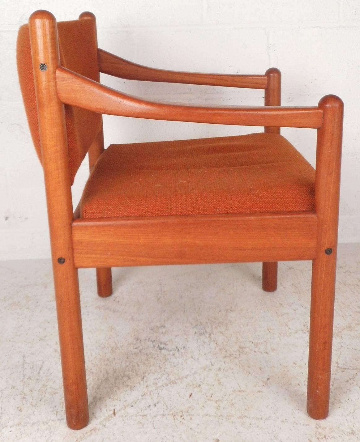 This beautiful vintage modern side chair features plush bright orange upholstery on the seat and backrest. Unique sculpted arm rests and cylindrical legs add to the allure. Extremely comfortable seating with elegant teak wood grain makes the perfect