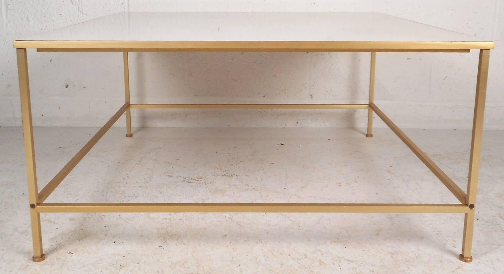 This beautiful vintage modern coffee table features a brass frame with stretchers between each leg. Elegant white laminate tabletop ensures a sturdy and stylish place to set any type of item. Mid-Century piece with an excellent straight line design