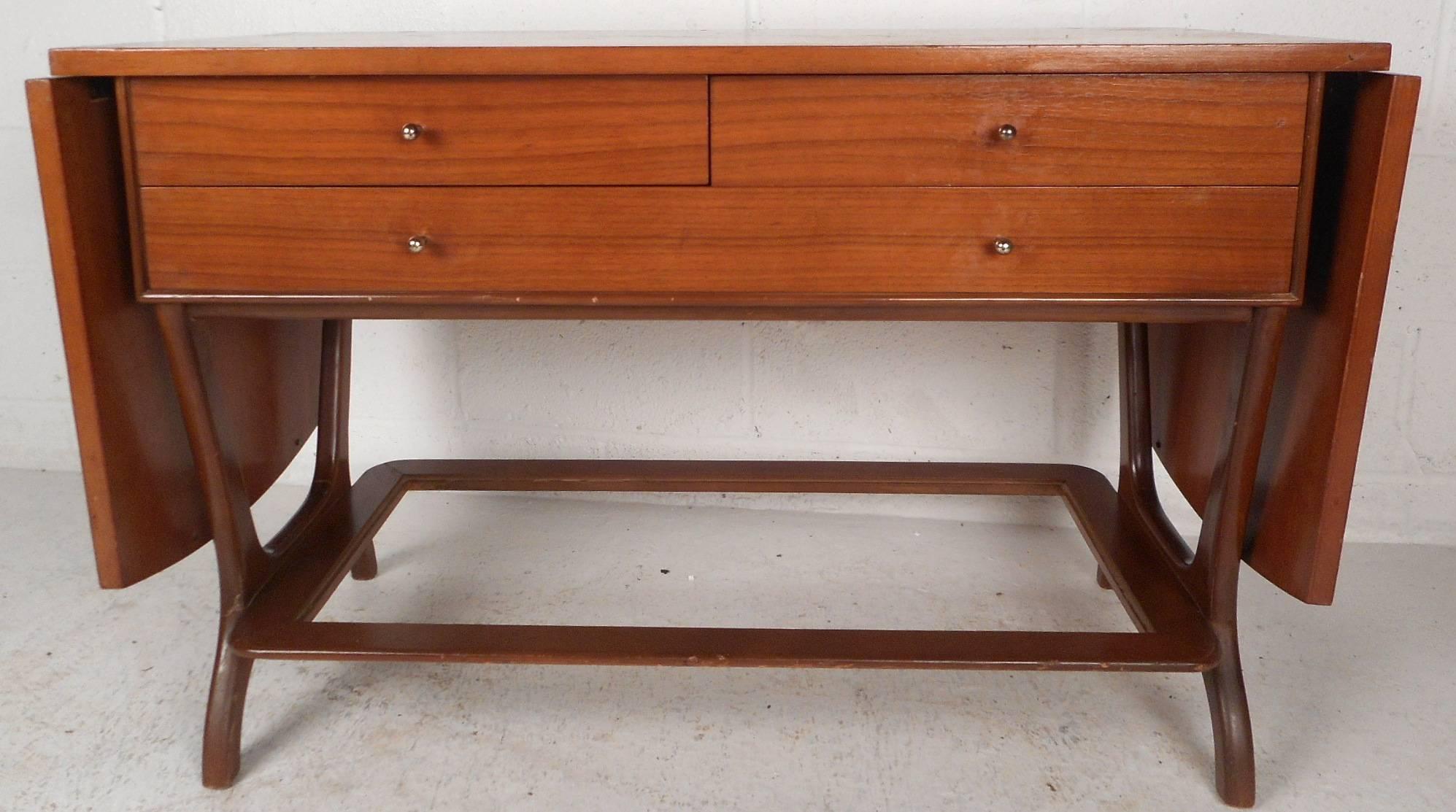 Esta hermosa pieza vintage moderna tiene dos hojas que amplían la anchura de la encimera hasta 76,5 pulgadas. Su diseño versátil funciona fácilmente como soporte de TV, mesa consola, mesa auxiliar o carrito para servir. Las preciosas vetas de madera