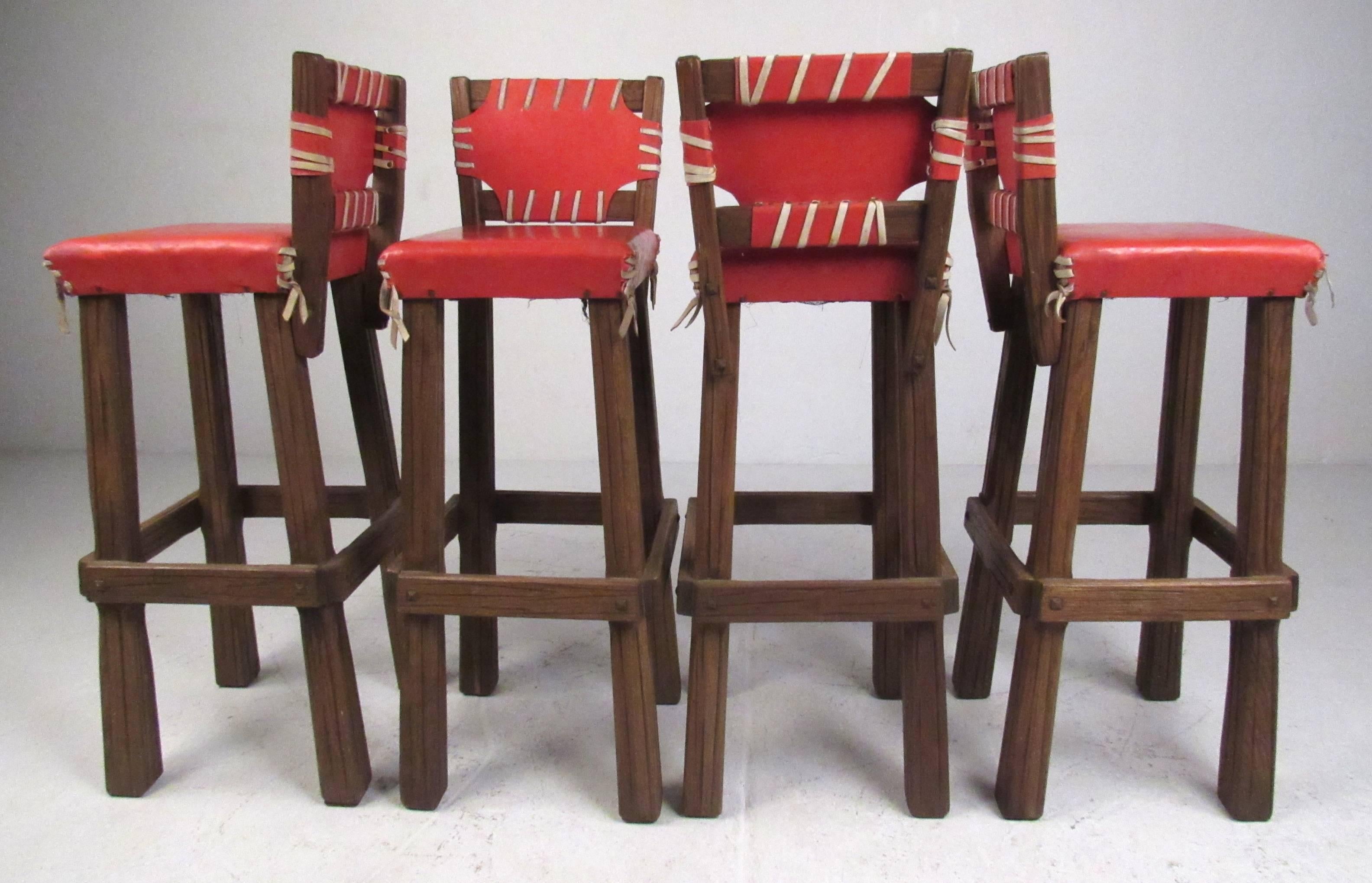 Rare set of Brandt Ranch solid oak bar stools with orange vinyl upholstery and suede tie backs. Please confirm item location (NY or NJ) with dealer.