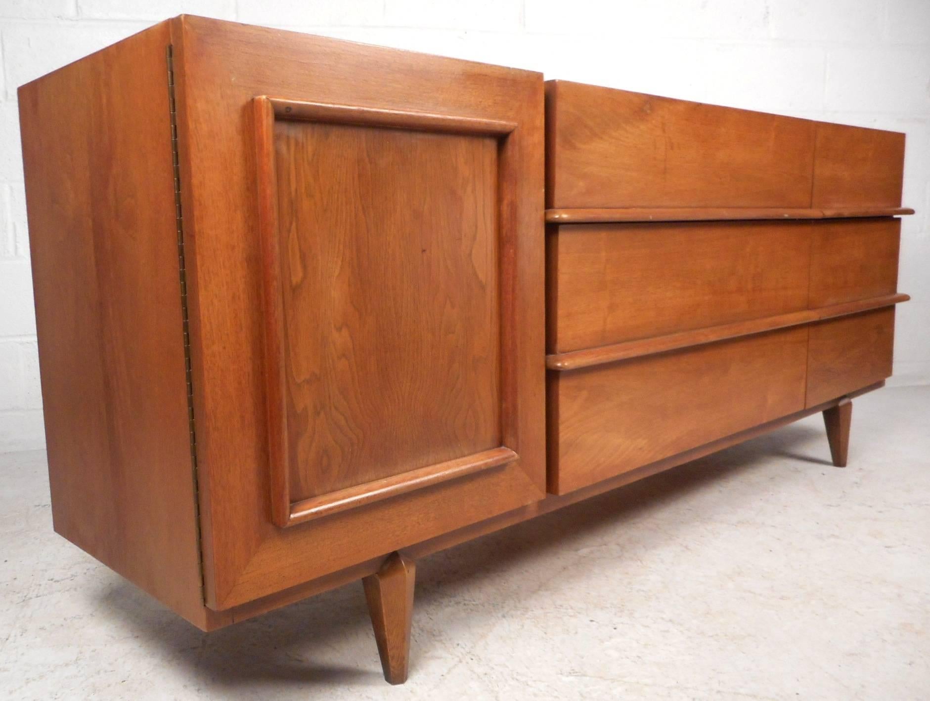 This stunning vintage modern bedroom set comes with a low dresser, a highboy, and two night stands. Stylish design with an over abundance of storage space within its many drawers. Unique low dresser has a cabinet door with an unusual embossed square