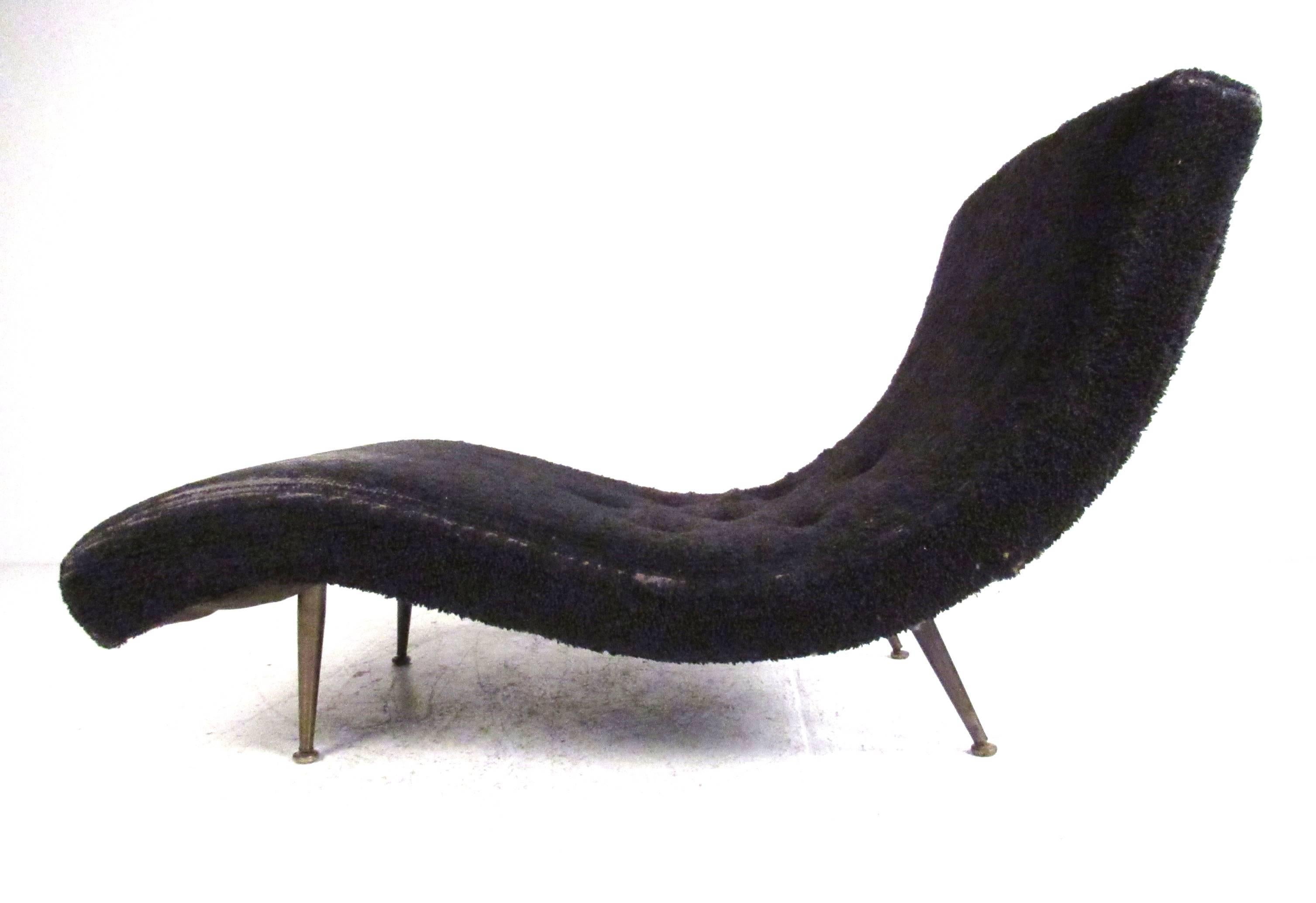 Sculptural Mid-Century Modern chaise longue with Classic wave form supported by brass tapered legs. Please confirm item location (NY or NJ) with dealer.