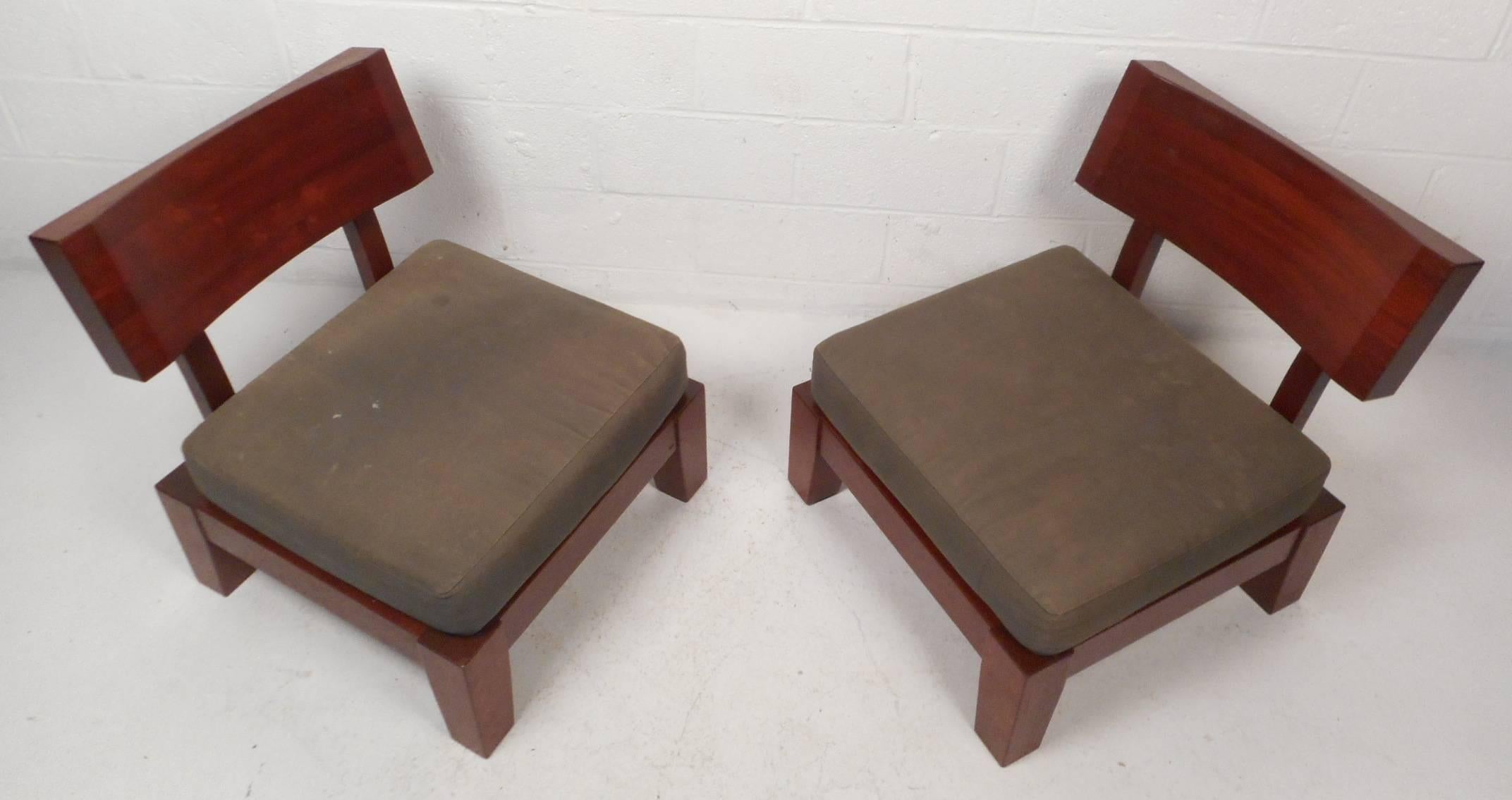 This gorgeous pair of vintage modern lounge chairs feature a unique backrest with beveled sides. Solid construction with elegant wood grain and thick padded seat cushions. Sleek and sturdy design is sure to compliment any seating arrangement. Please