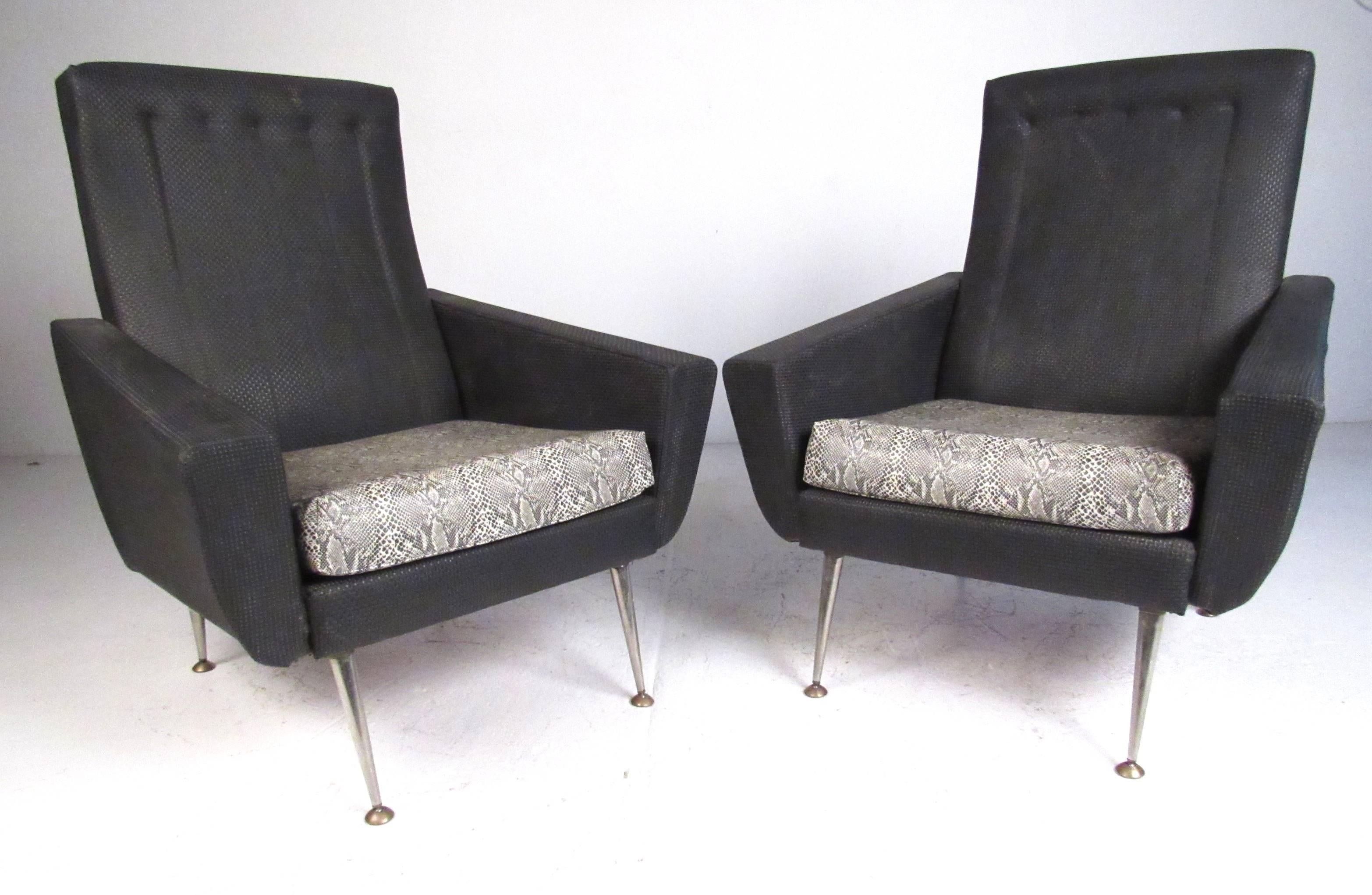 Generously proportioned pair of vintage high back lounge chairs in the manner of Gio Ponti. Covered in a woven/textured black vinyl upholstery with chrome tapered legs with brass foot pads. Please confirm item location (NY or NJ) with dealer.