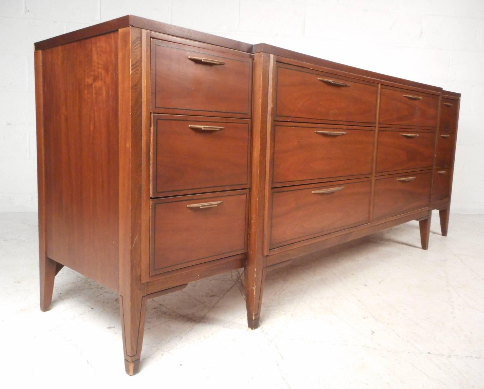 This stunning vintage modern dresser features a sculpted front with twelve drawers. Sleek design offers plenty of room for storage without sacrificing style. Extremely unique case piece with sculpted pulls, splayed legs, and a center that protrudes