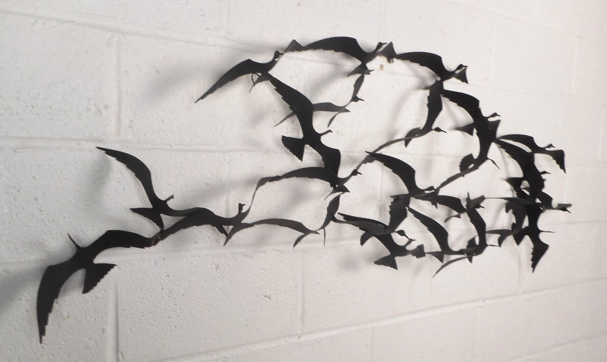 This beautiful vintage modern wall art features numerous sculpted birds in the flying pose. The unique design uses intricate detail to create a majestic display of a flock of birds. Unusual wall sculpture shows true quality with its sturdy