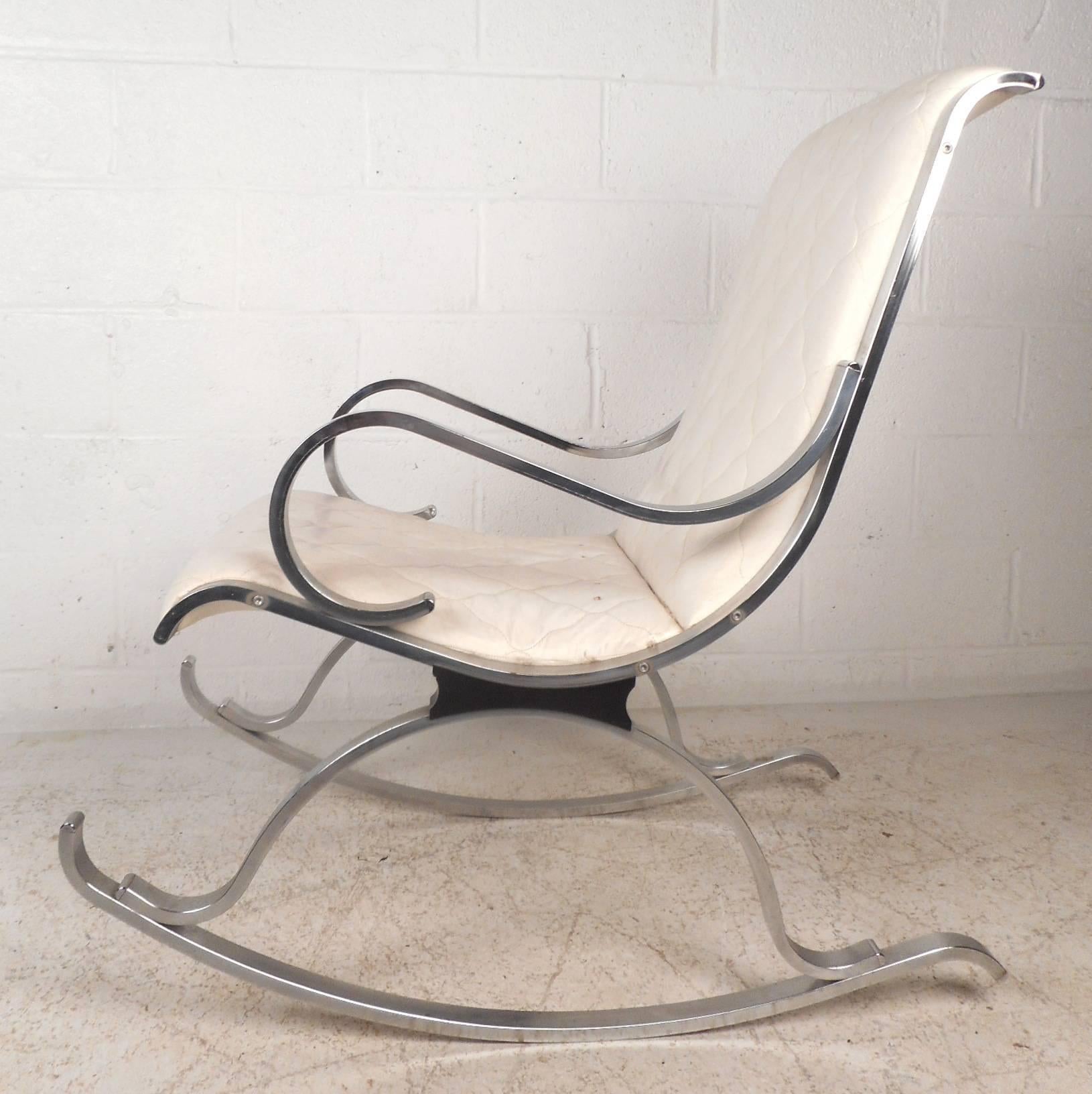 This lovely vintage modern rocking chair features a unique sculpted bent chrome frame and white leather upholstery. This unique rocker has perfectly placed arm rests for optimal comfort. The elegant white leather seating and heavy chrome base show