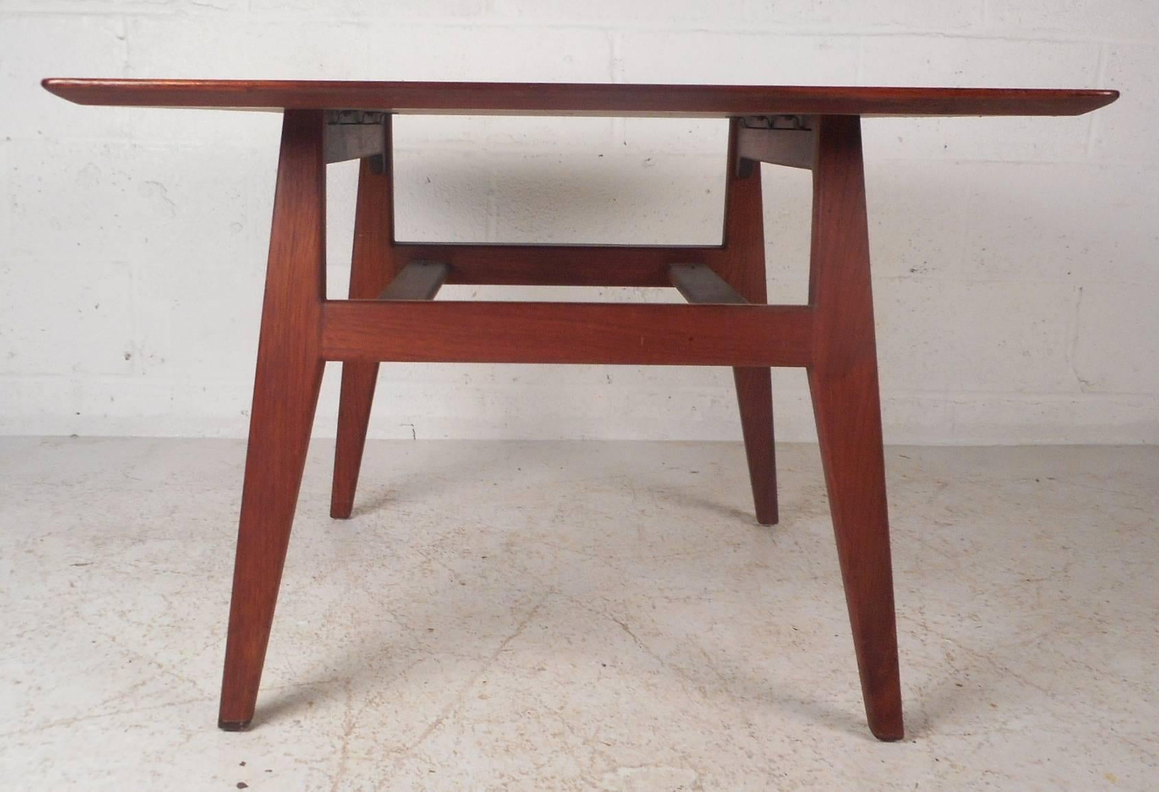 Stunning vintage modern end table by designer Jens Risom features elegant wood grain on a large top with smooth edges. Unique mid-century design with angled and tapered legs all connected by stretchers. This versatile piece can also be used as a