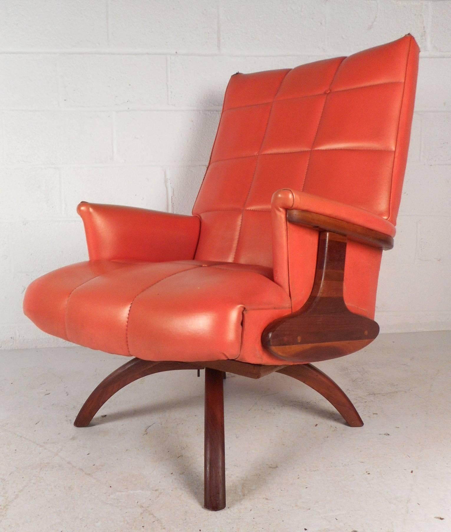 This beautiful vintage modern lounge chair and ottoman feature unique curved walnut legs. Sleek design with over stuffed seating covered in elaborate orange vinyl. Amazing sculpted sides and arm rests with gorgeous walnut wood grain add to the