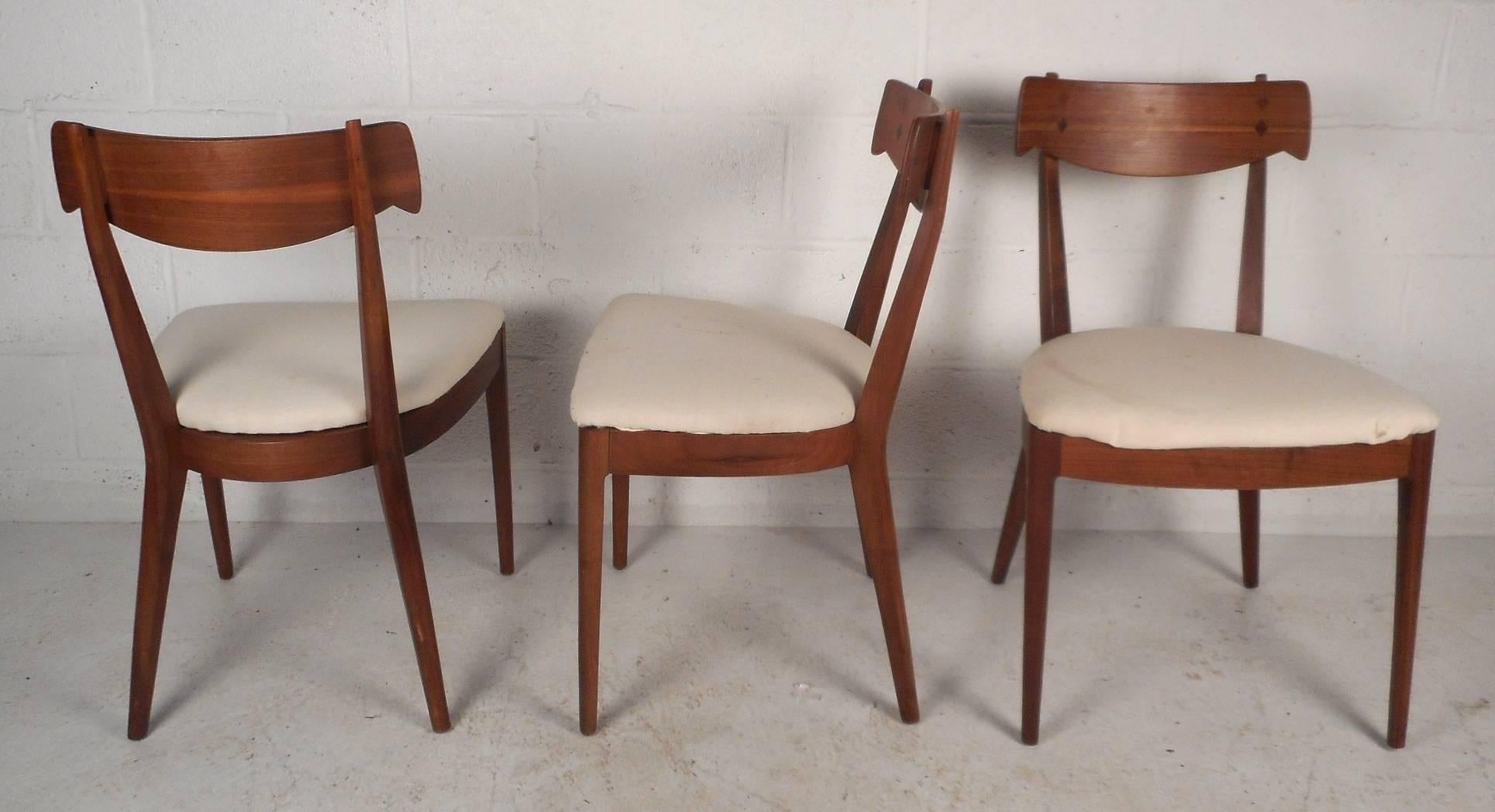 This beautiful set of four vintage modern dining chairs by Kipp Stewart for Drexel make an impression in any setting. Sleek design has sculpted back rests with rosewood diamond shaped inlays and unusual splayed back legs. Plush white upholstered