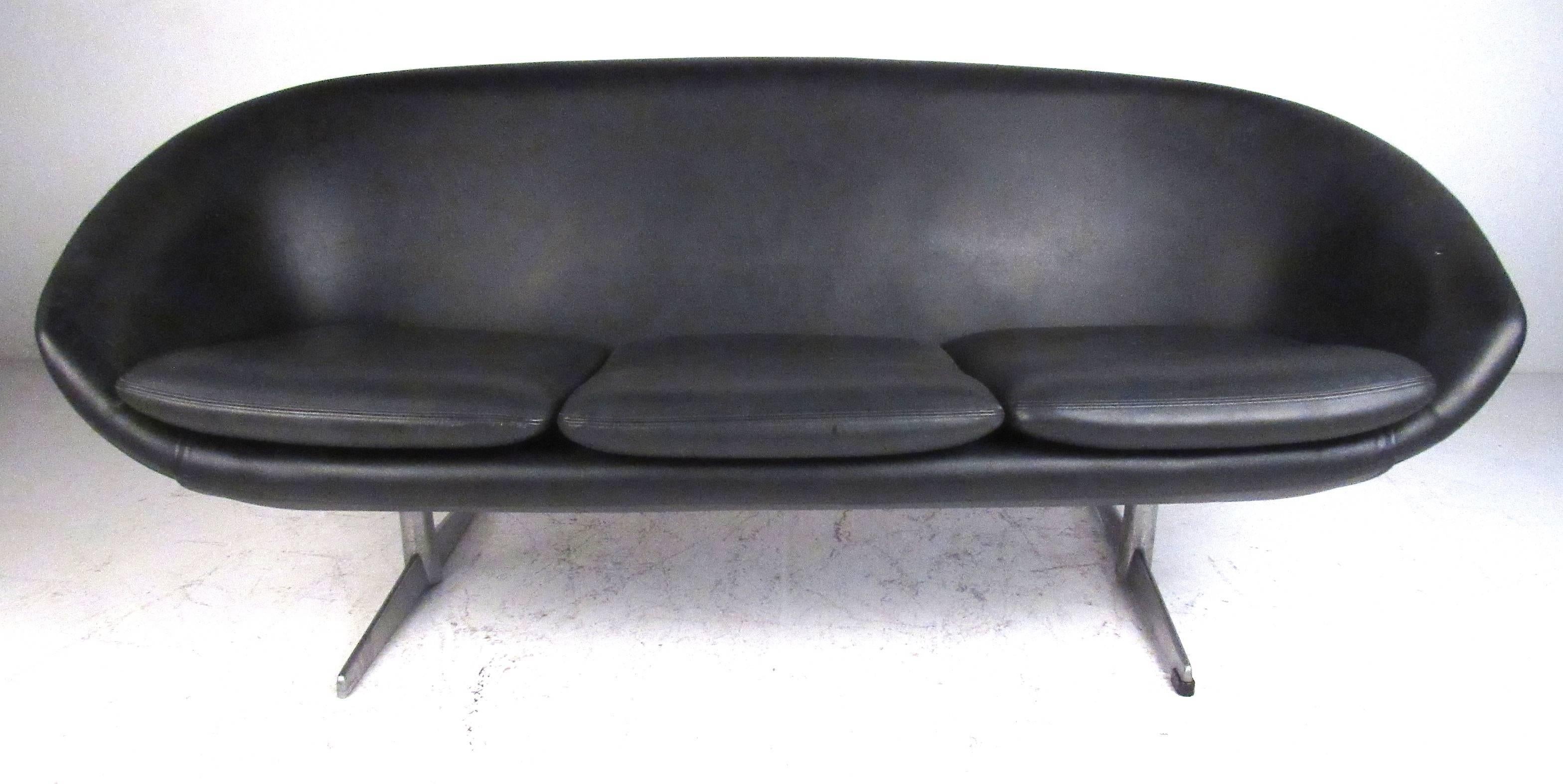 This sculptural molded urethane foam construction sofa is very light weight but durable. Vintage original black vinyl upholstery with brushed aluminium legs, it was manufactured by Swedish producer Overman for their U.S.A. division. Please confirm