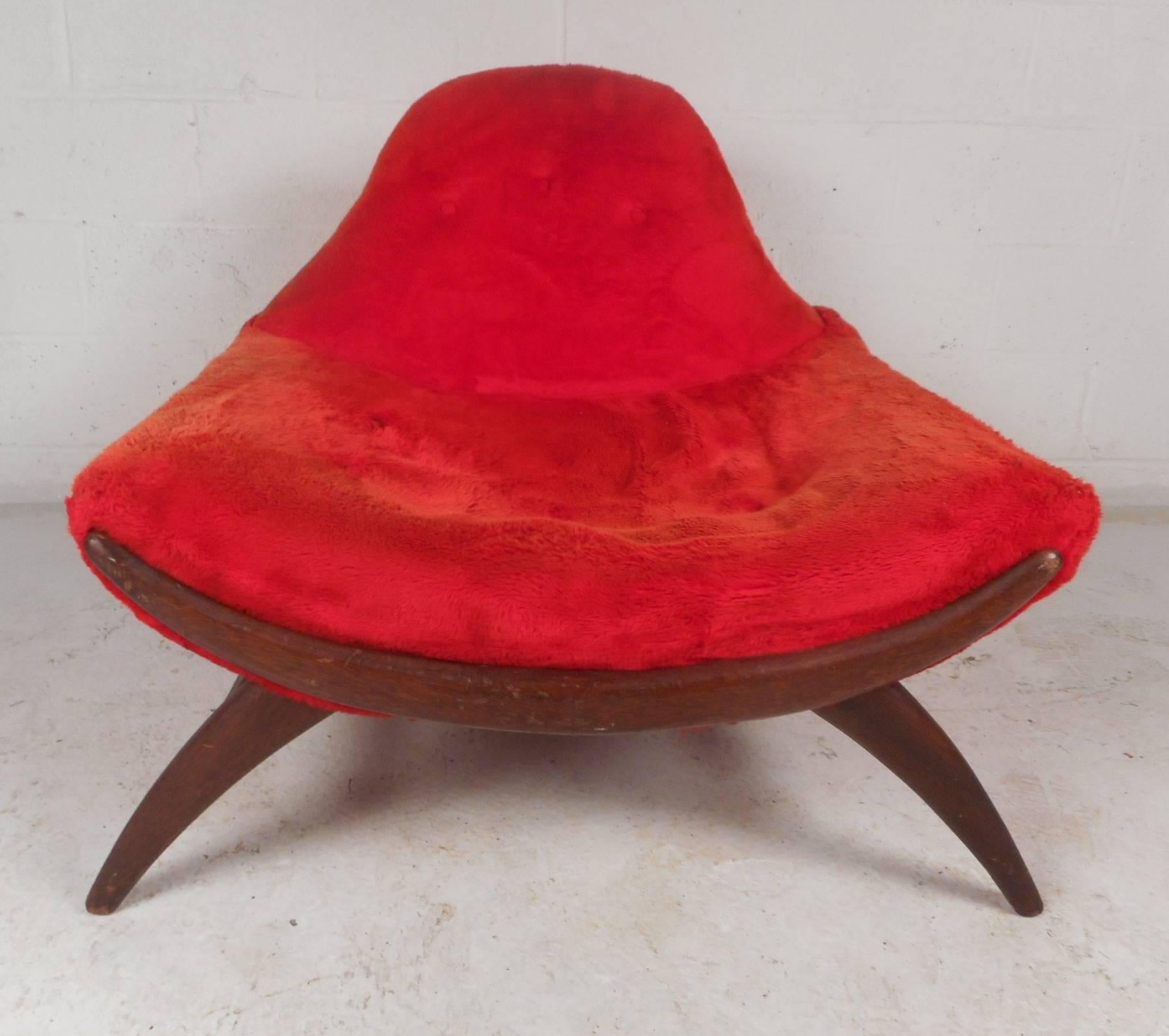This beautiful vintage modern lounge chair features an unusual curved front and sculpted frame. Extremely comfortable design with thick padded seating and elaborate plush red upholstery. Quality construction with a sturdy walnut frame makes this