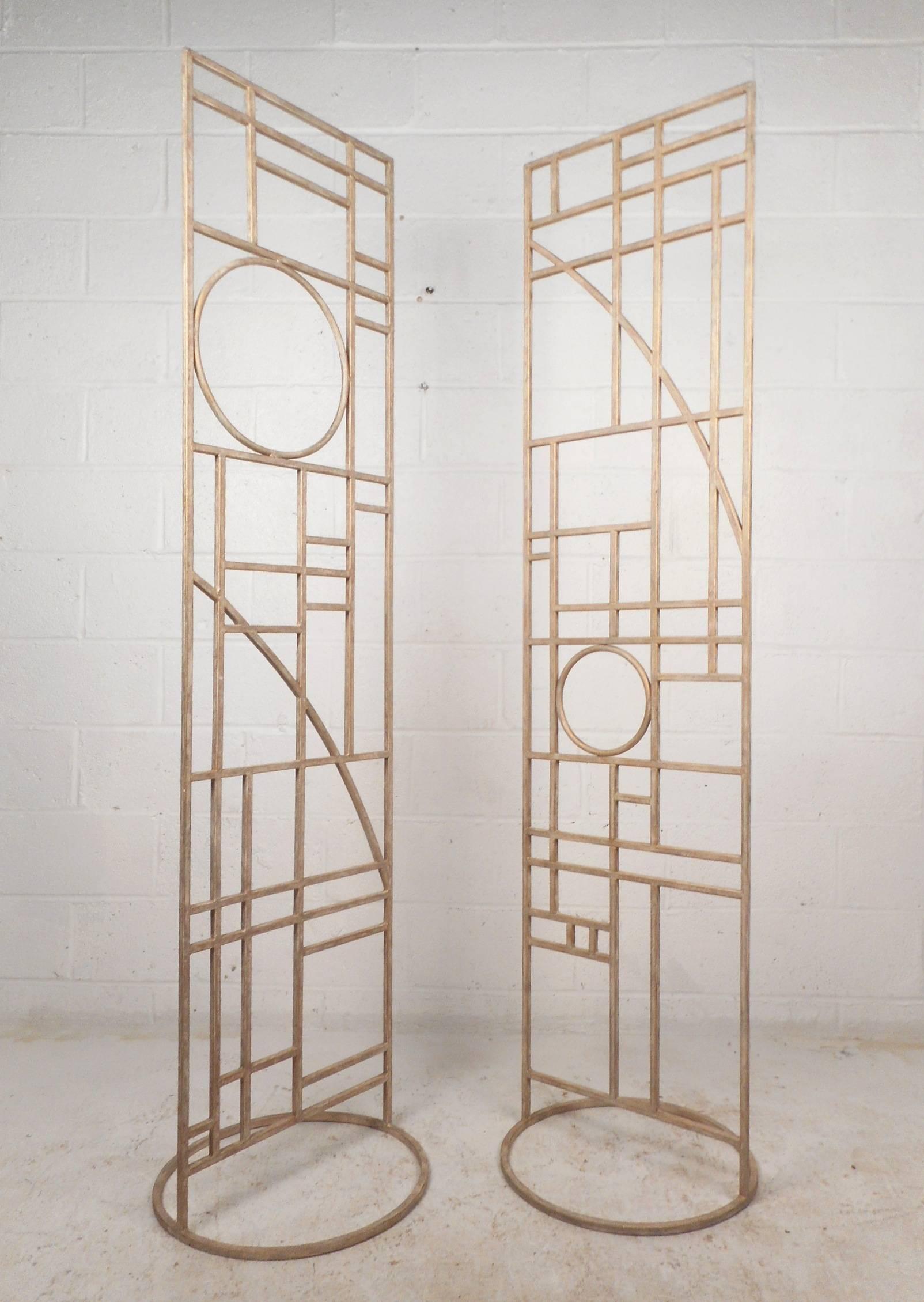 Beautiful pair of vintage modern room dividers made of metal with a sleek gold brushed finish. Elegant rectangular design with numerous geometric shapes on top of a sturdy circular base. Versatile pieces work perfectly as a screen for dividing areas