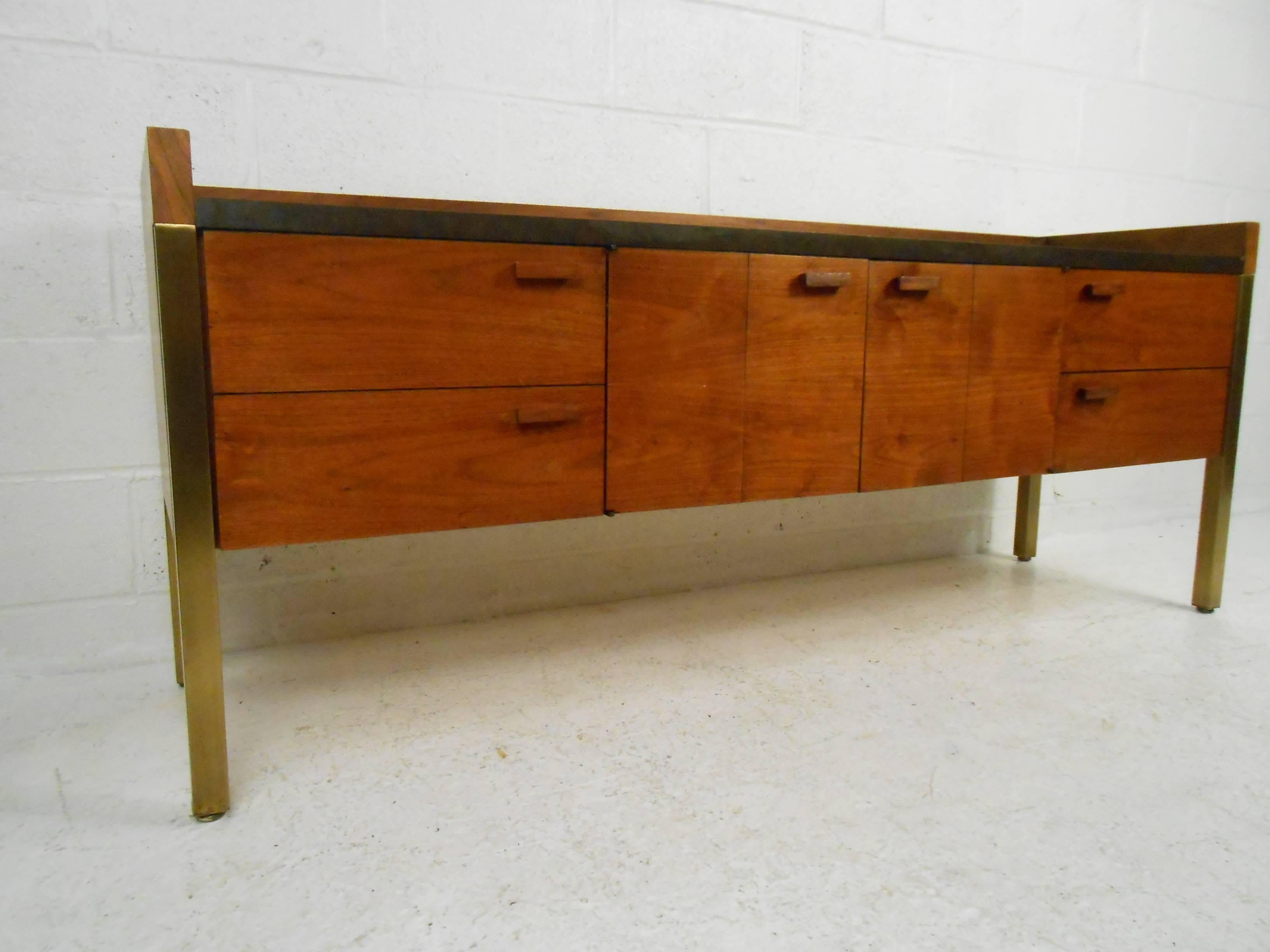 Stunning vintage modern sideboard with four drawers and a two folding cabinets hiding a compartment in the centre. This beautiful case piece features a black formica top with raised wood edges surrounding the sides and back. Unusual carved pulls,