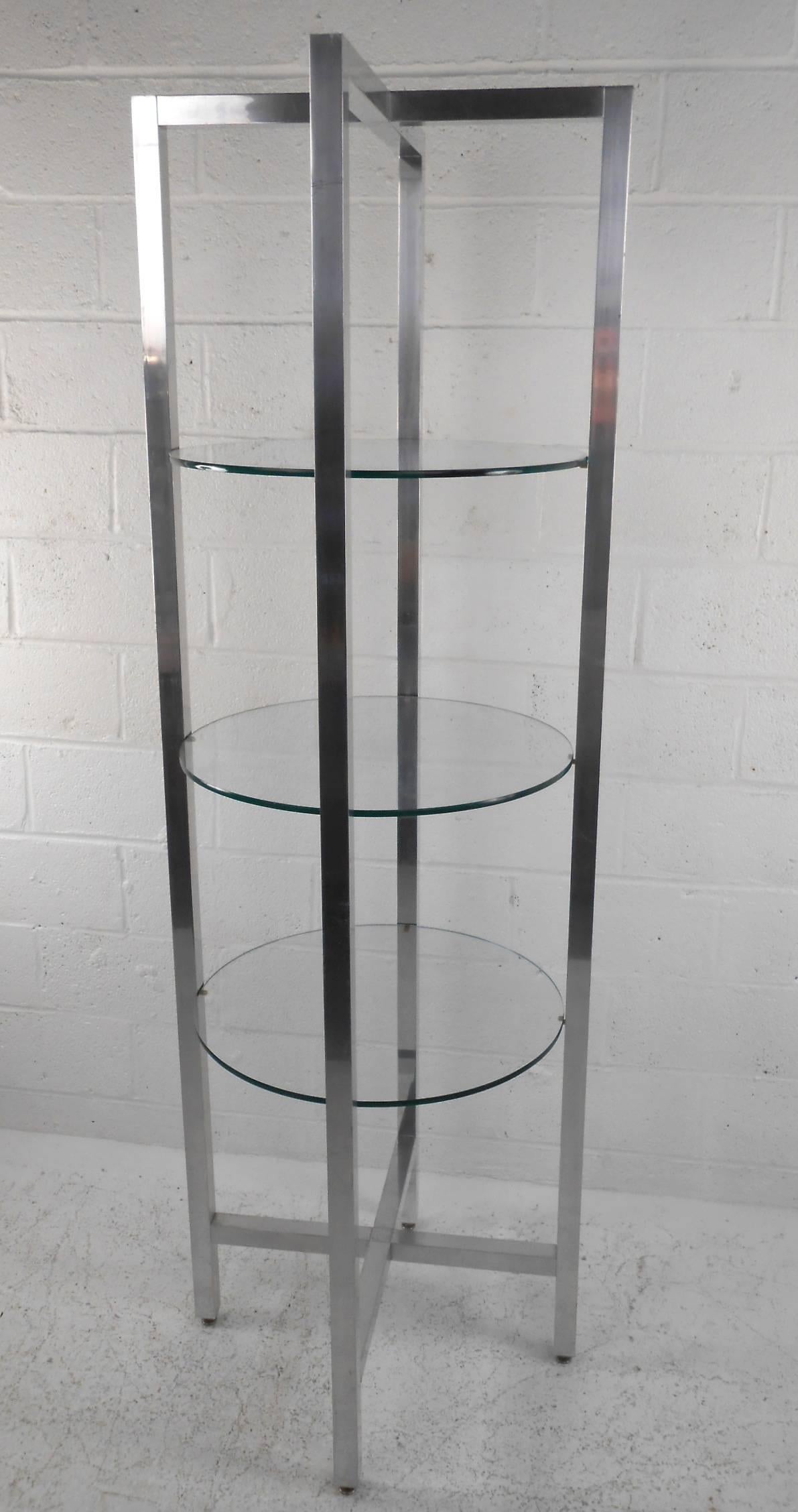 This beautiful vintage modern étagère features a heavy circular chrome frame with three round glass shelves. Stylish design with four supports running all the way from bottom to top forming an 