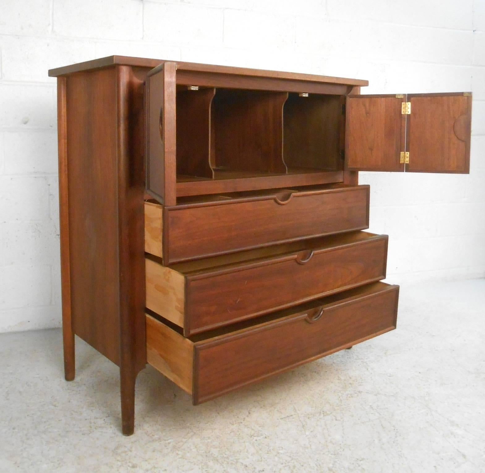 Beautiful vintage modern chest with a large compartment with spacers hidden by two cabinet doors and three hefty drawers. Stylish design has unusual recessed ellipse cut-out pulls on each cabinet and drawer. This solid walnut Mid-Century case piece