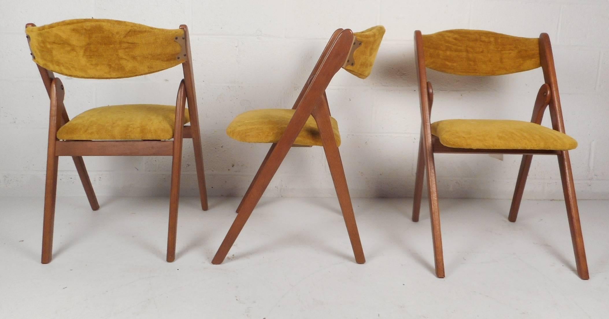 This beautiful set of six vintage modern dining chairs feature plush yellow upholstery and the ability to fold up for storage. Sleek design has a curved backrest ensuring maximum comfort. Quality craftsmanship on display with angled legs and