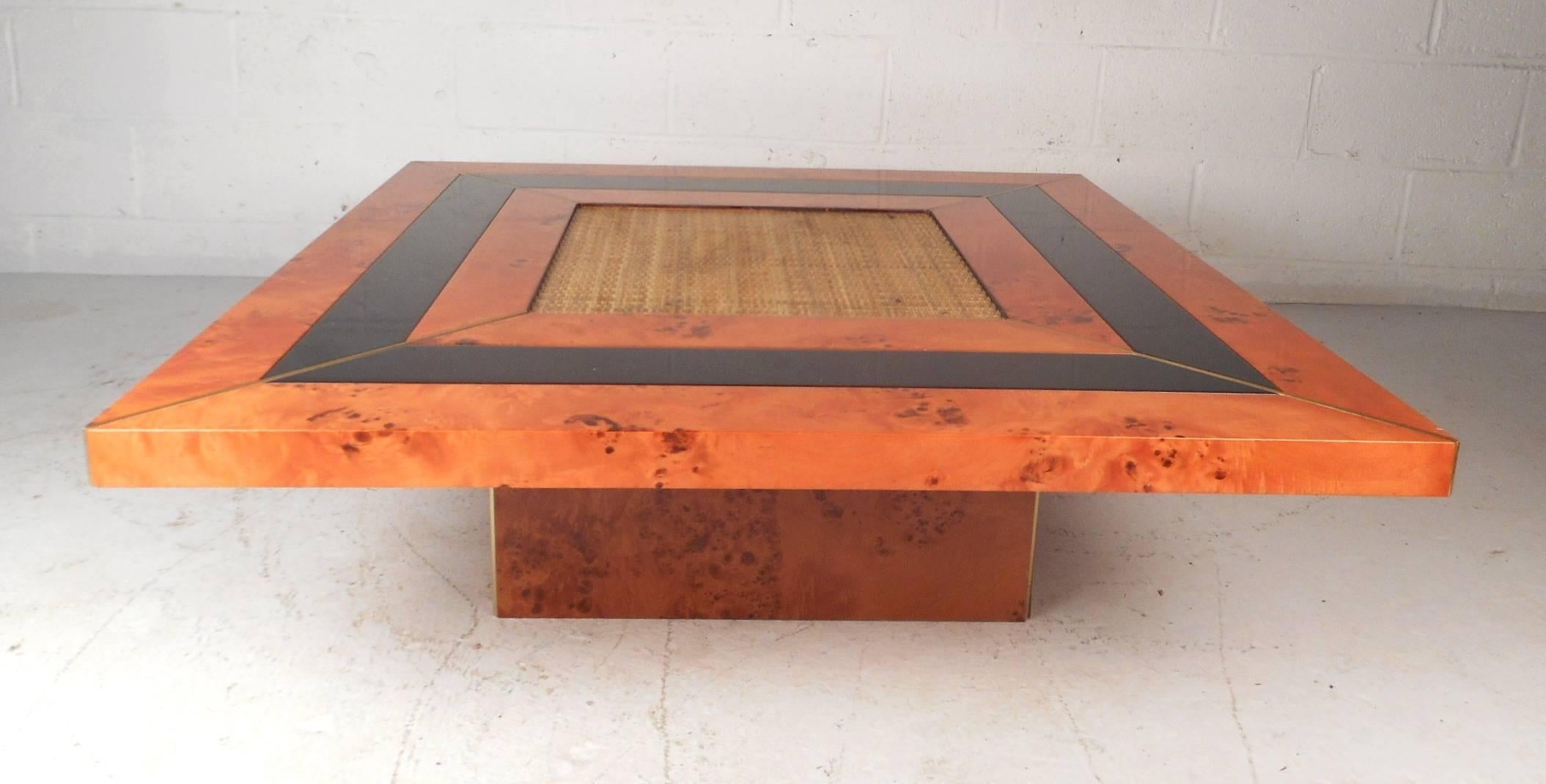 This beautiful vintage modern coffee table is made of burl wood with a woven center. Sleek low design with a black lacquer strip wrapping all the way around the top between the burl. This unusual piece has brass trim running from each corner to the